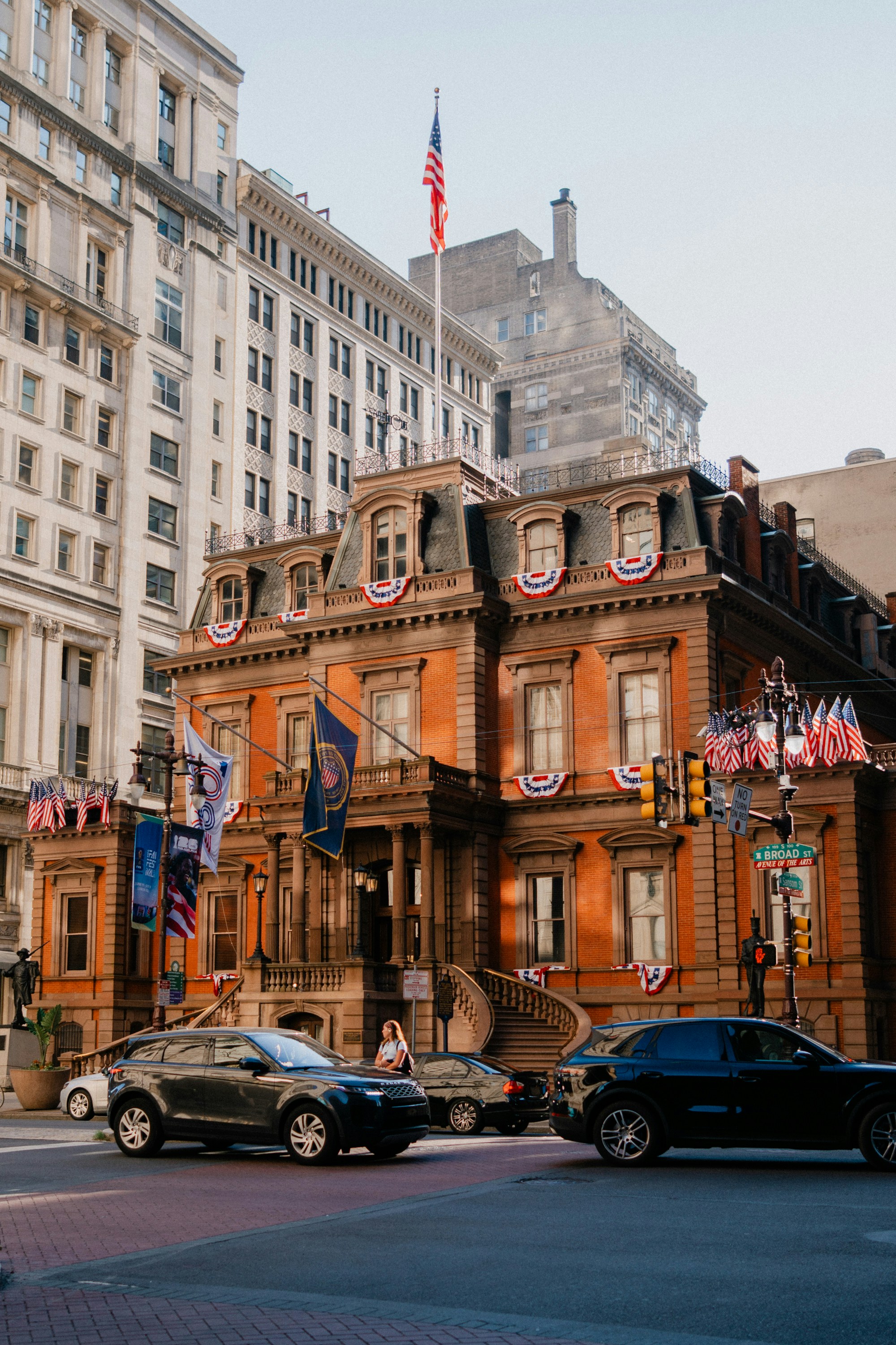 Ornate historic building with patriotic bunting on a city street.