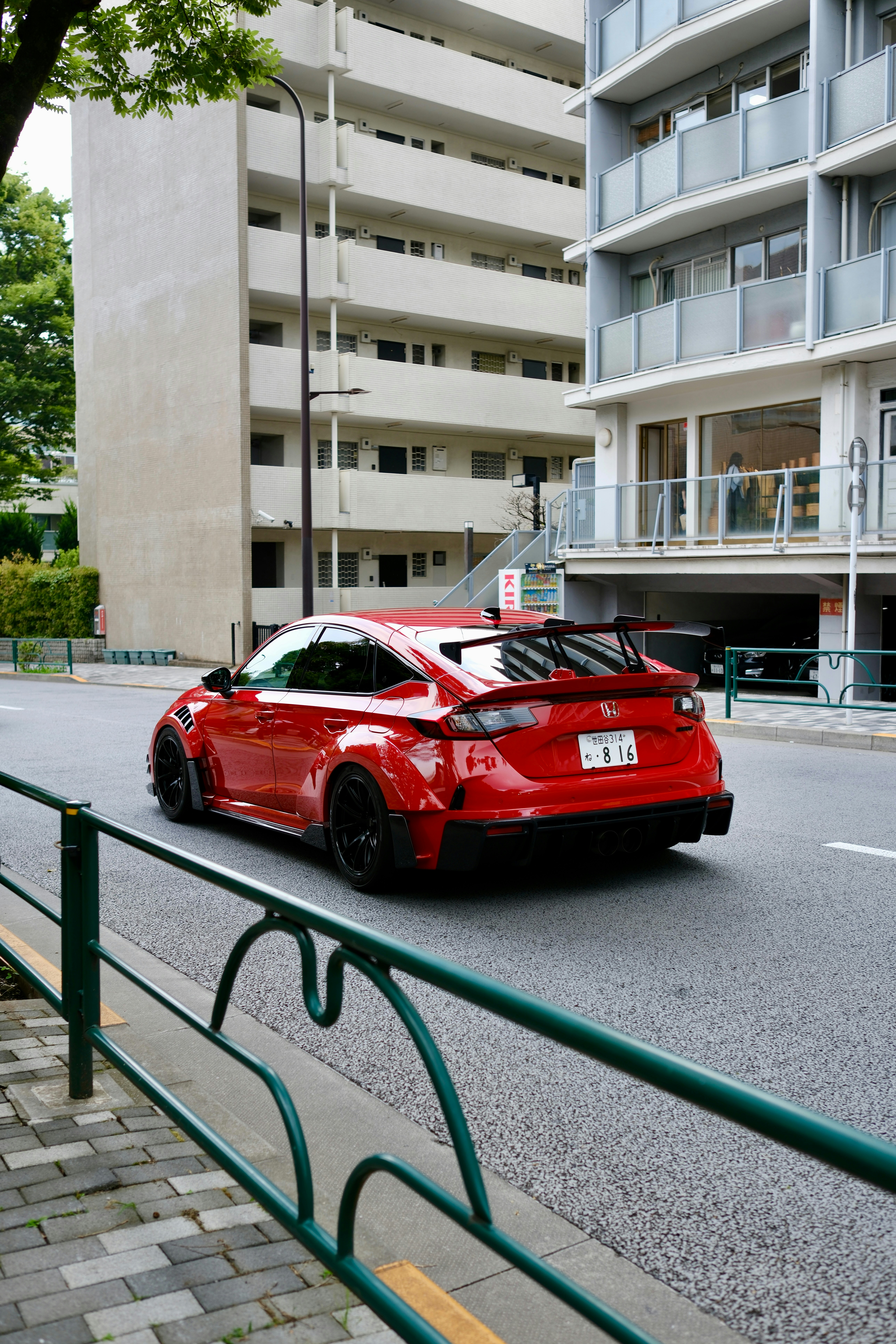 Voiture de sport rouge roulant dans une rue de ville.