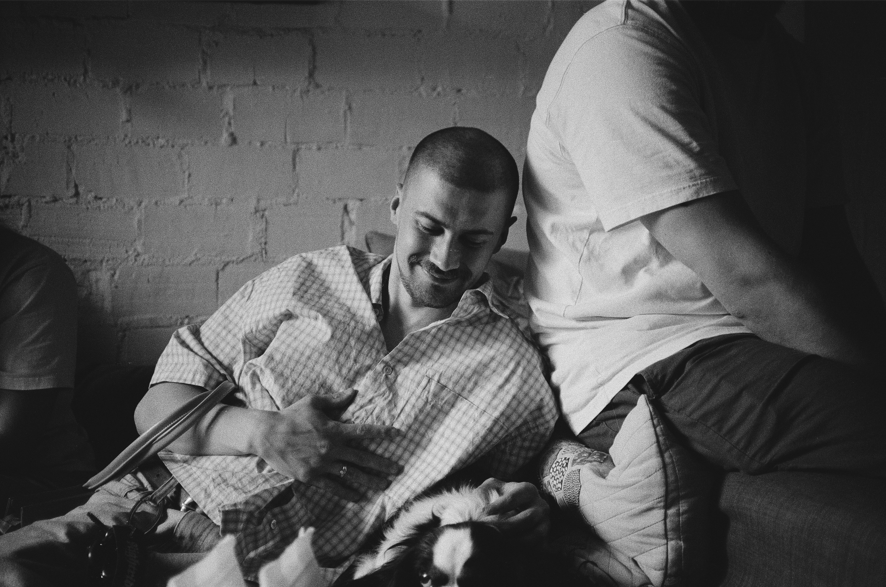 A man in a plaid shirt smiling indoors
