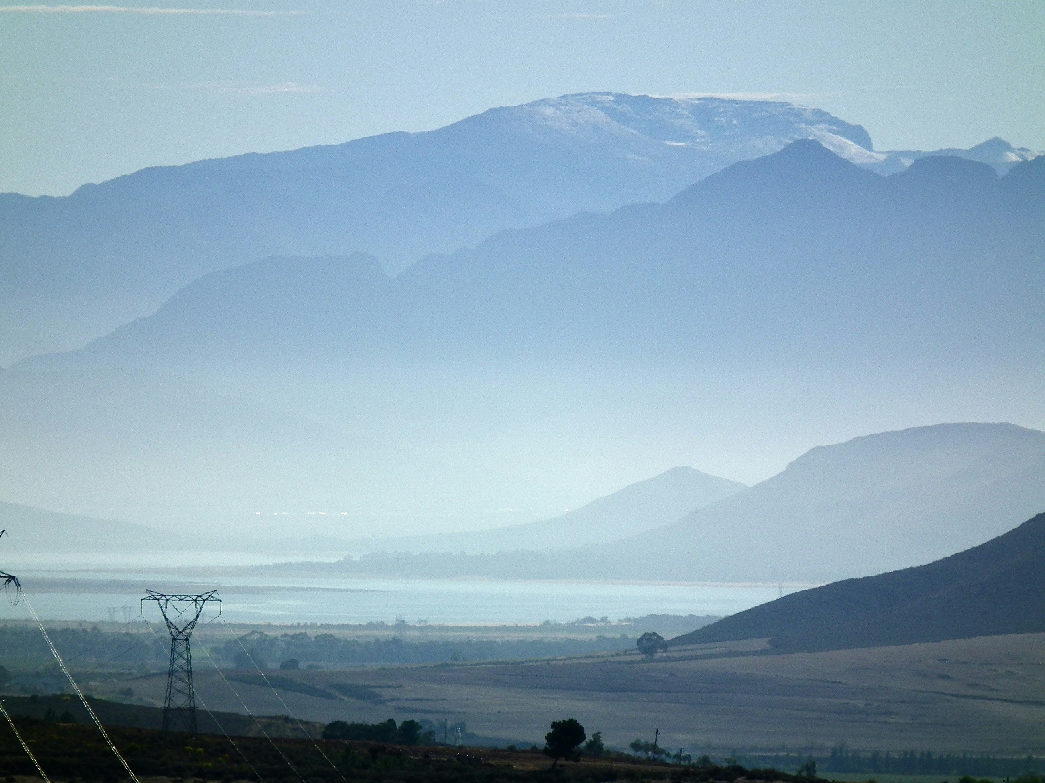 Des montagnes bleues lointaines et une vallée brumeuse avec une tour d’alimentation.