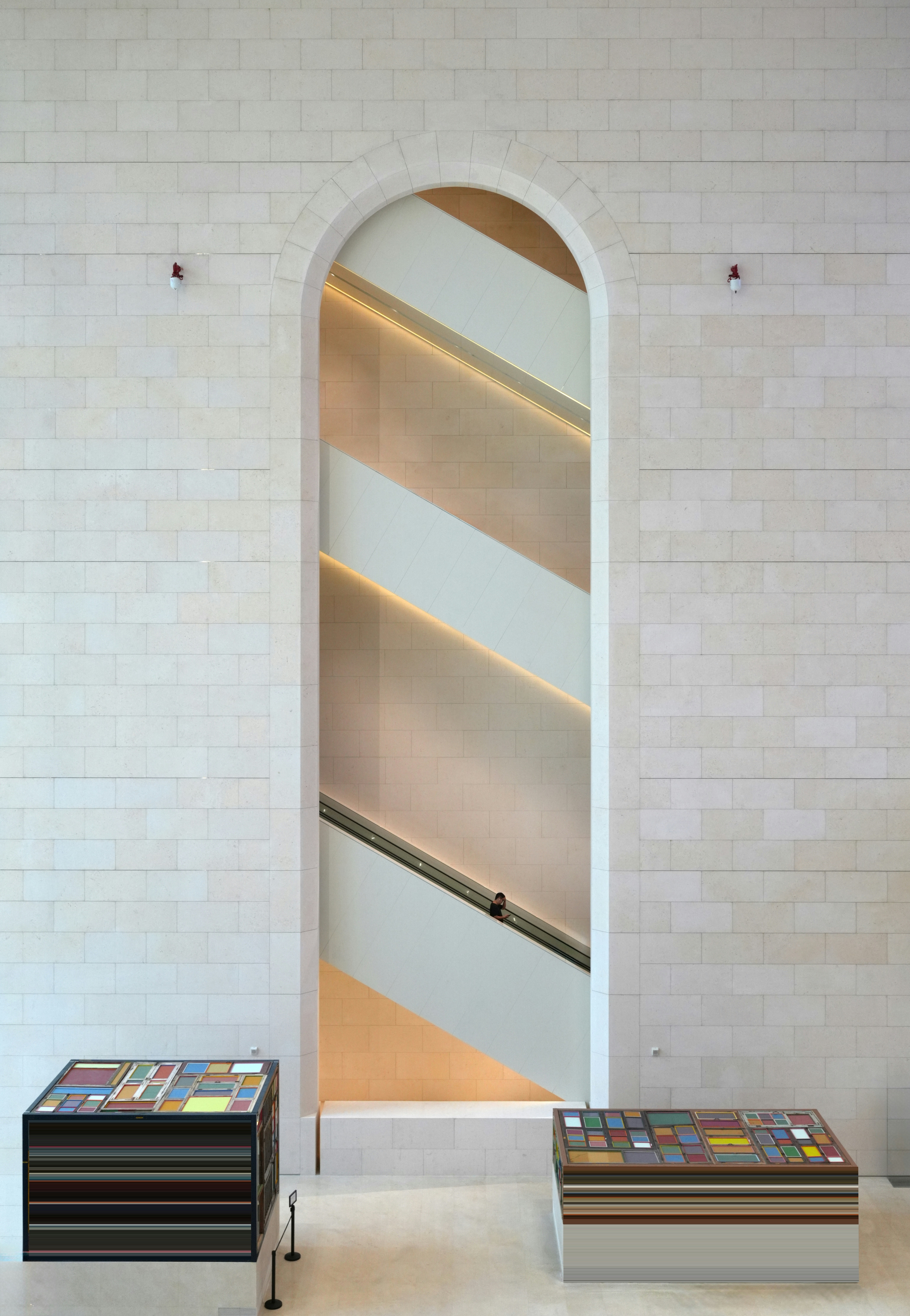 Modern arched doorway revealing staircase with colorful patterned benches.