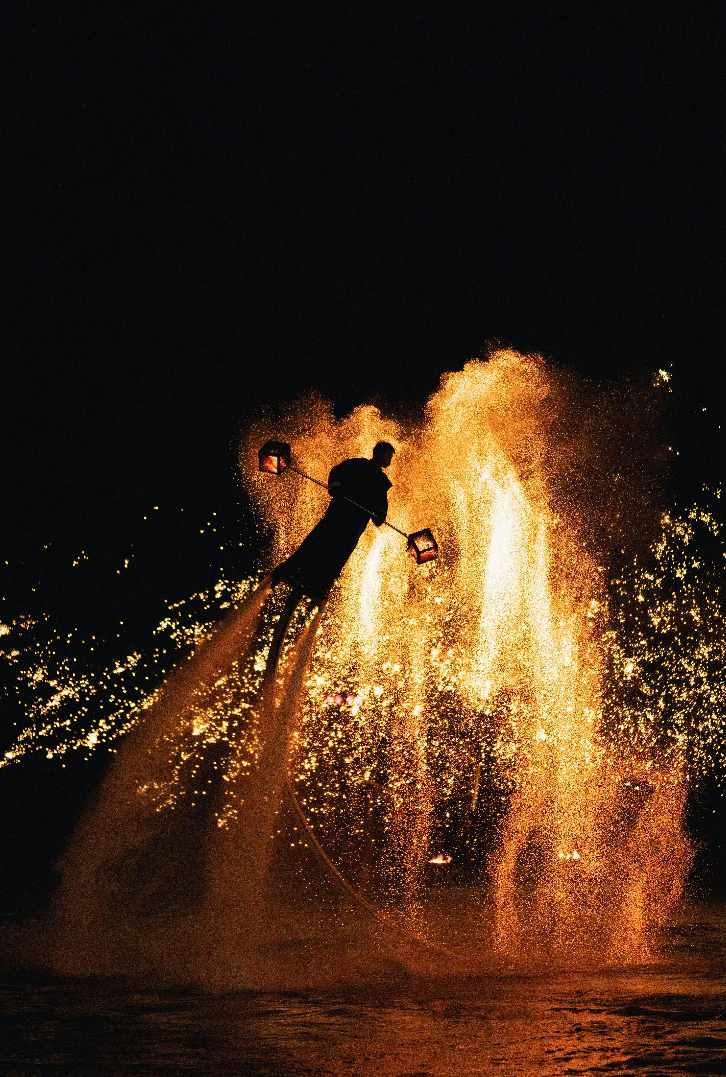 Jetboarder performing with a spectacular display of fire and sparks.
