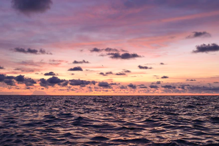 A beautiful sunset over the ocean with colorful clouds.