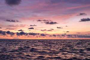 A beautiful sunset over the ocean with colorful clouds.