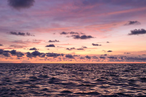 A beautiful sunset over the ocean with colorful clouds.