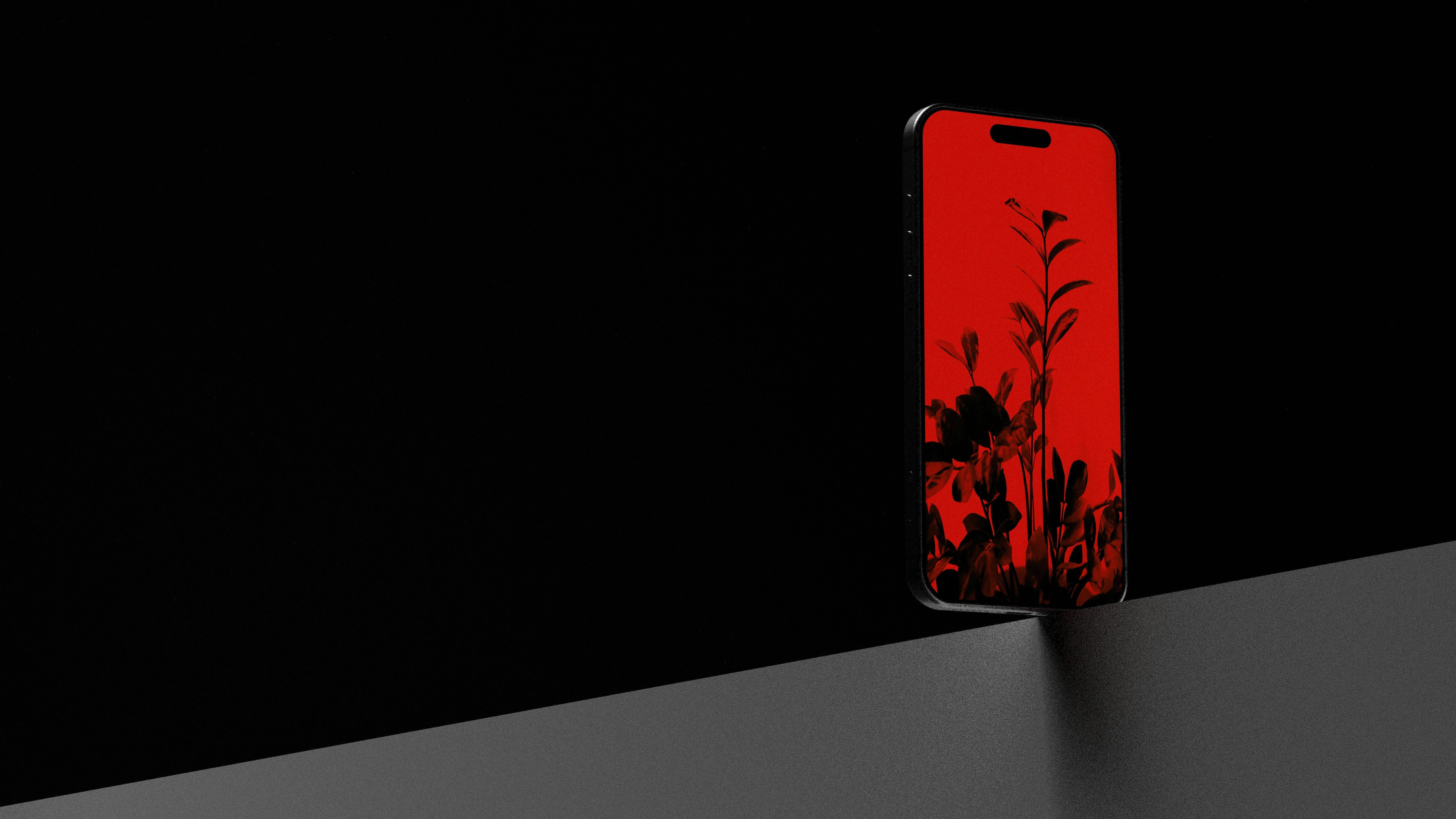 A smartphone with a red screen displaying a plant design.