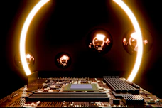 Electronic circuit board illuminated by orange glowing rings.