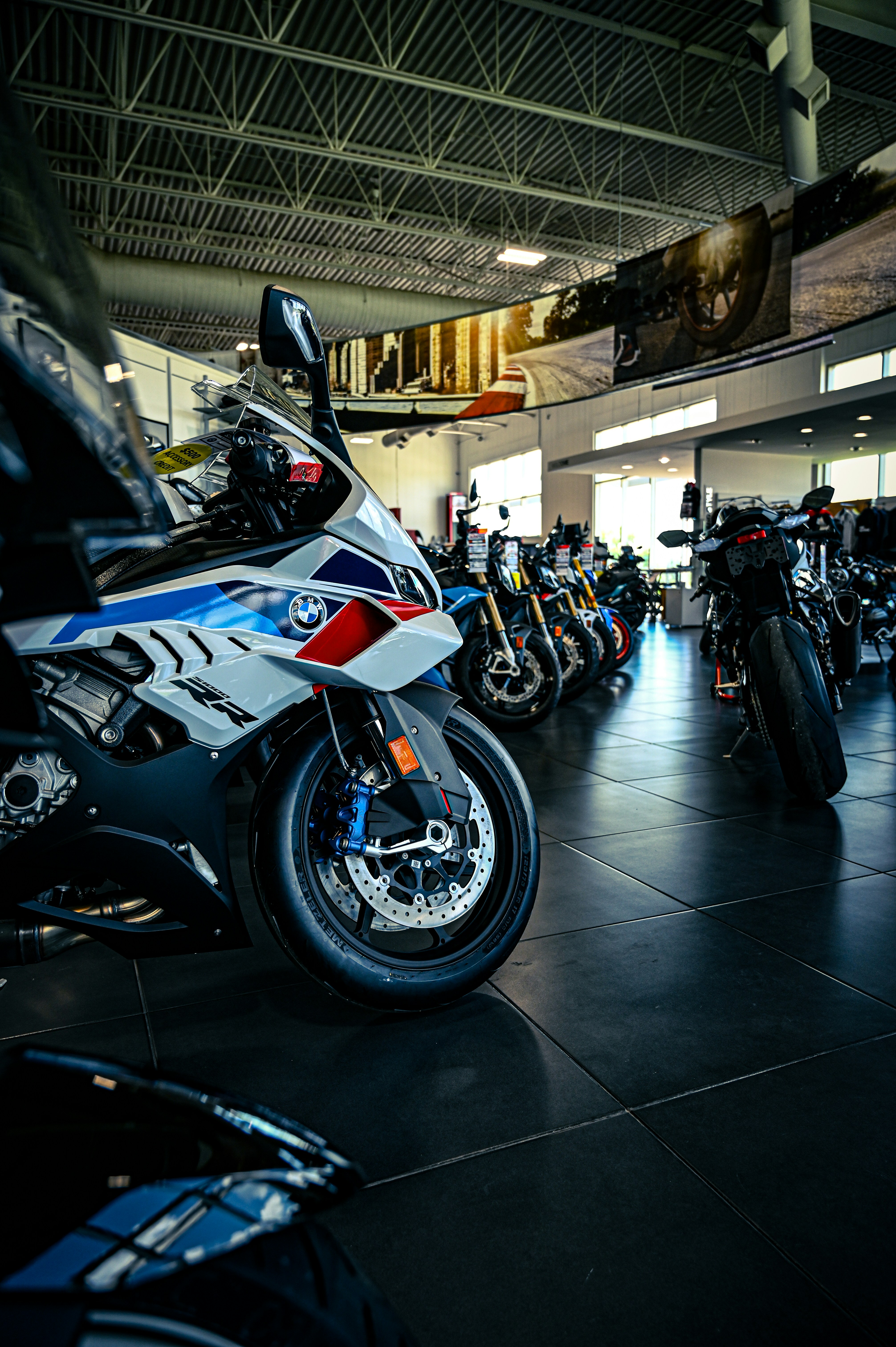 A showroom filled with various motorcycles, including a BMW sportbike.