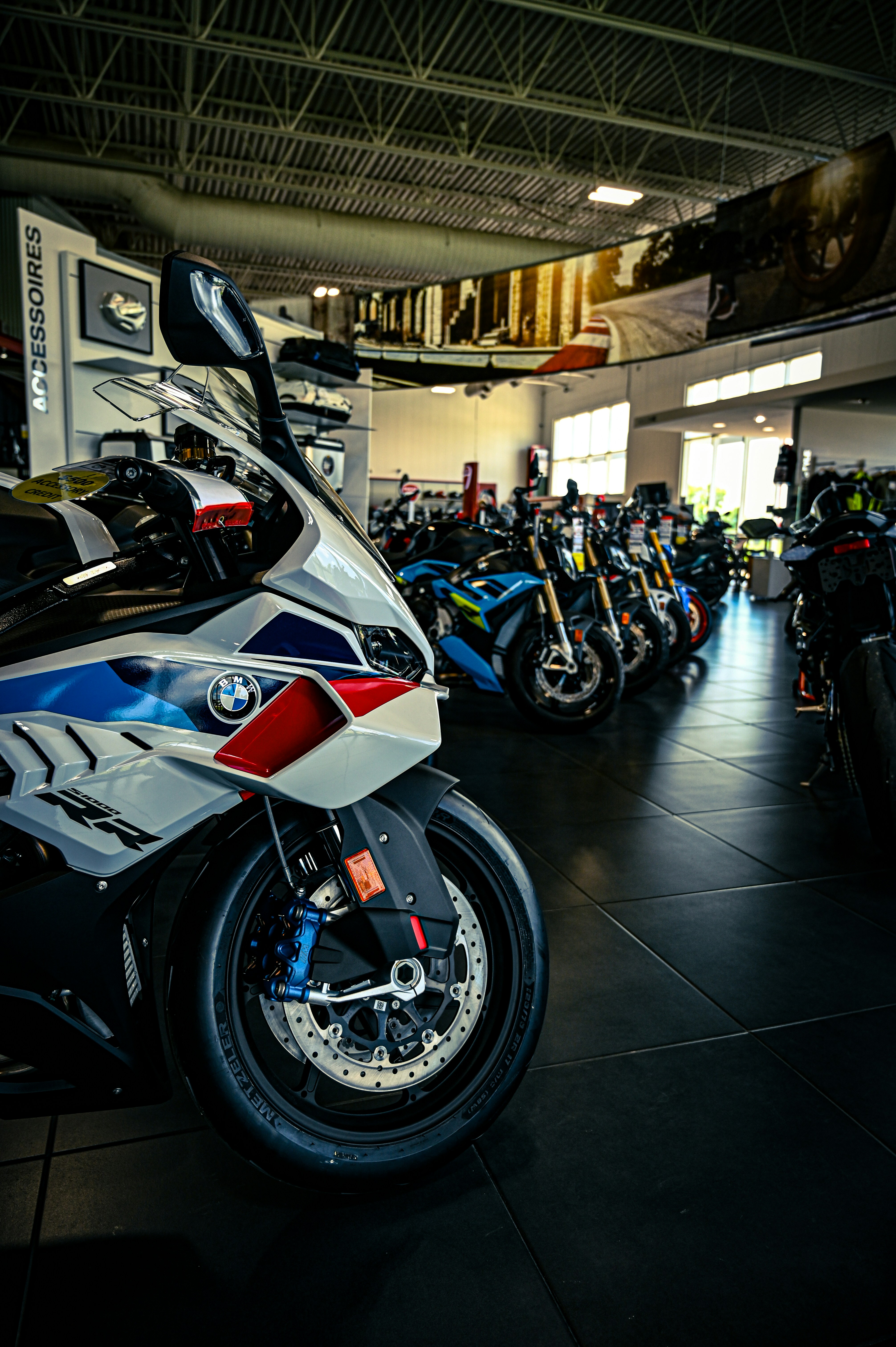 A white and blue BMW motorcycle in a dealership showroom.