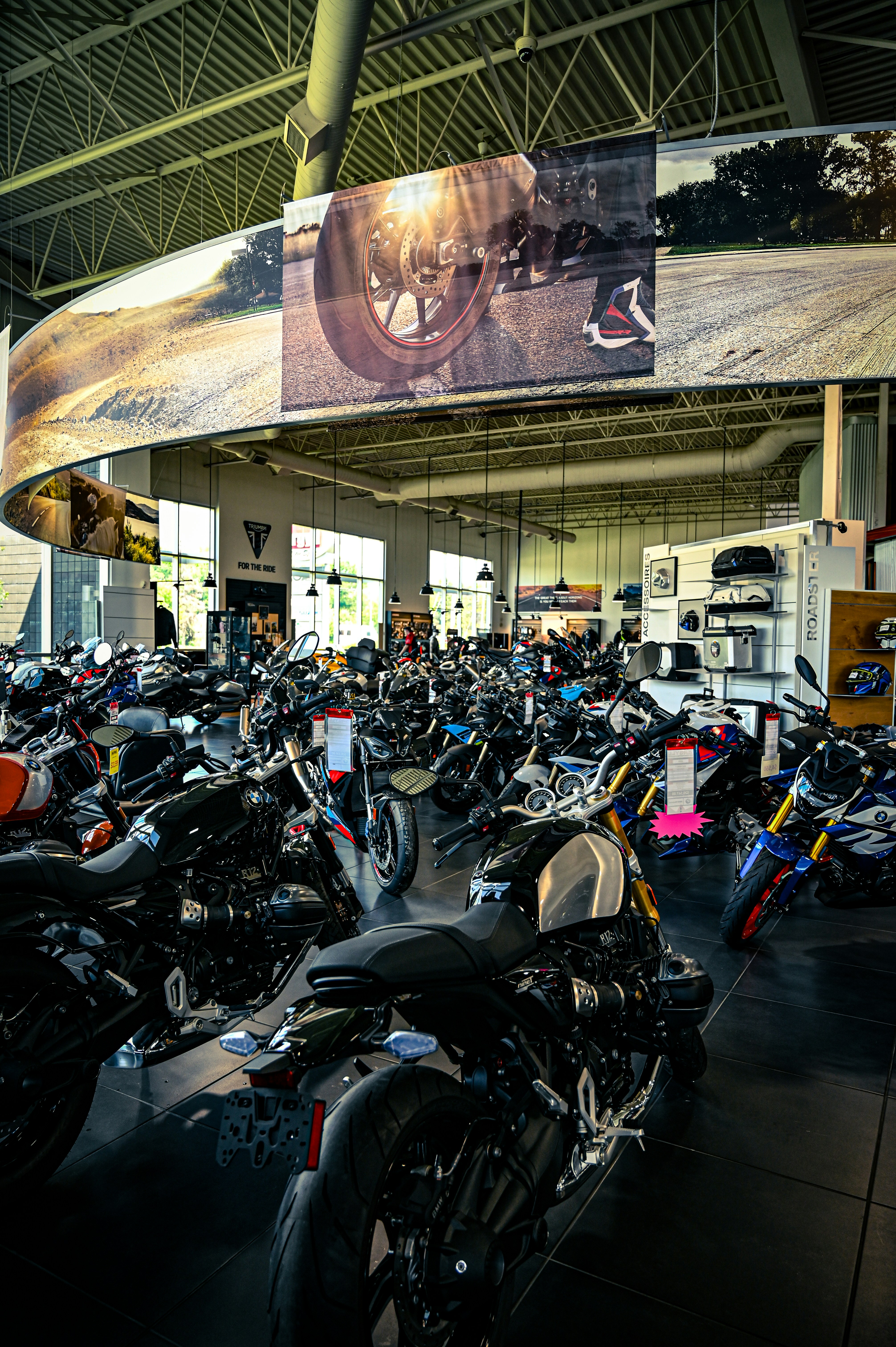 Rows of new motorcycles displayed inside a bright dealership.