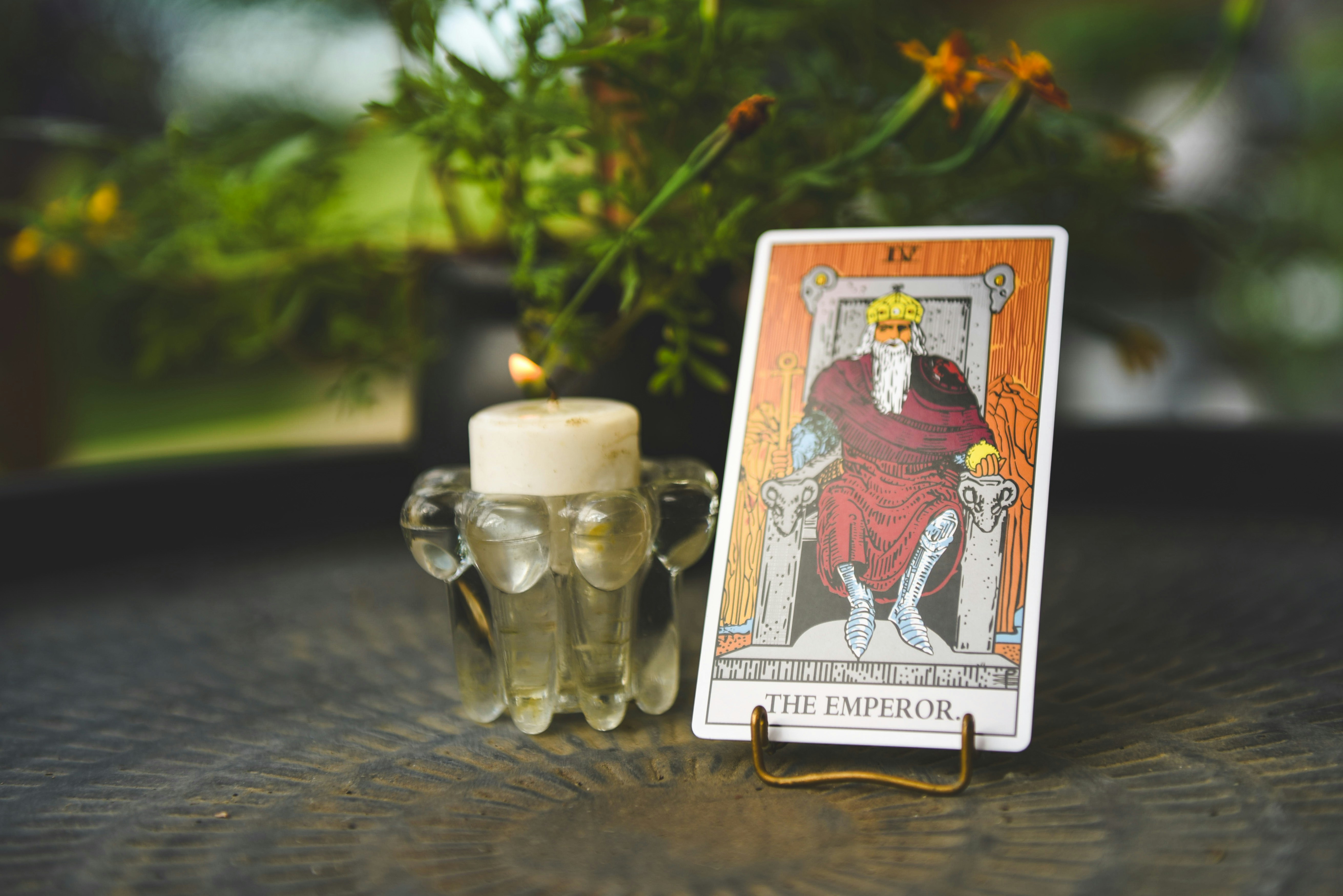 Lit candle beside The Emperor tarot card