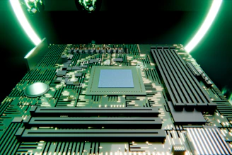 Green circuit board with a central processor and glowing light.