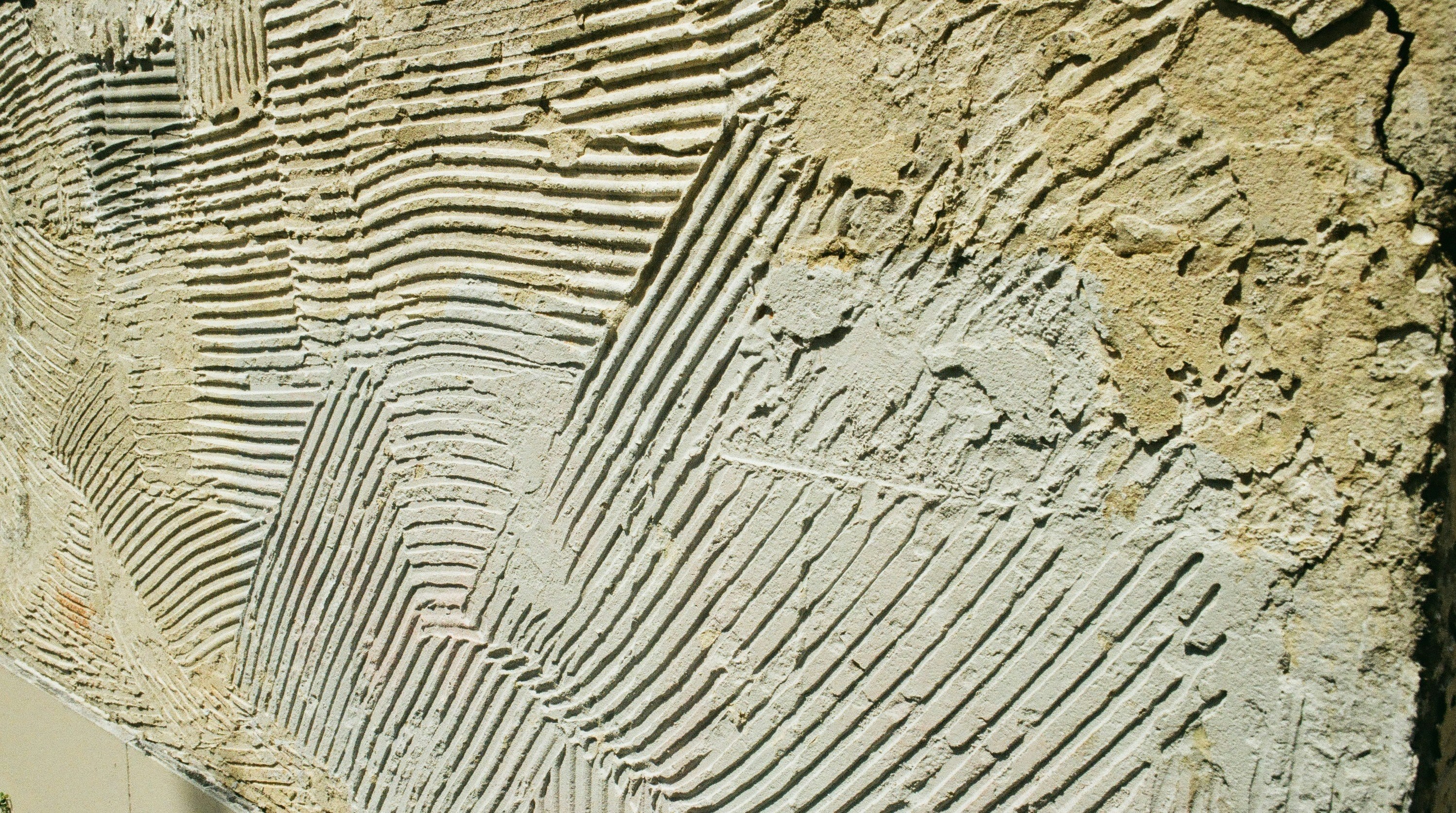 Textured wall surface with horizontal and diagonal grooves.