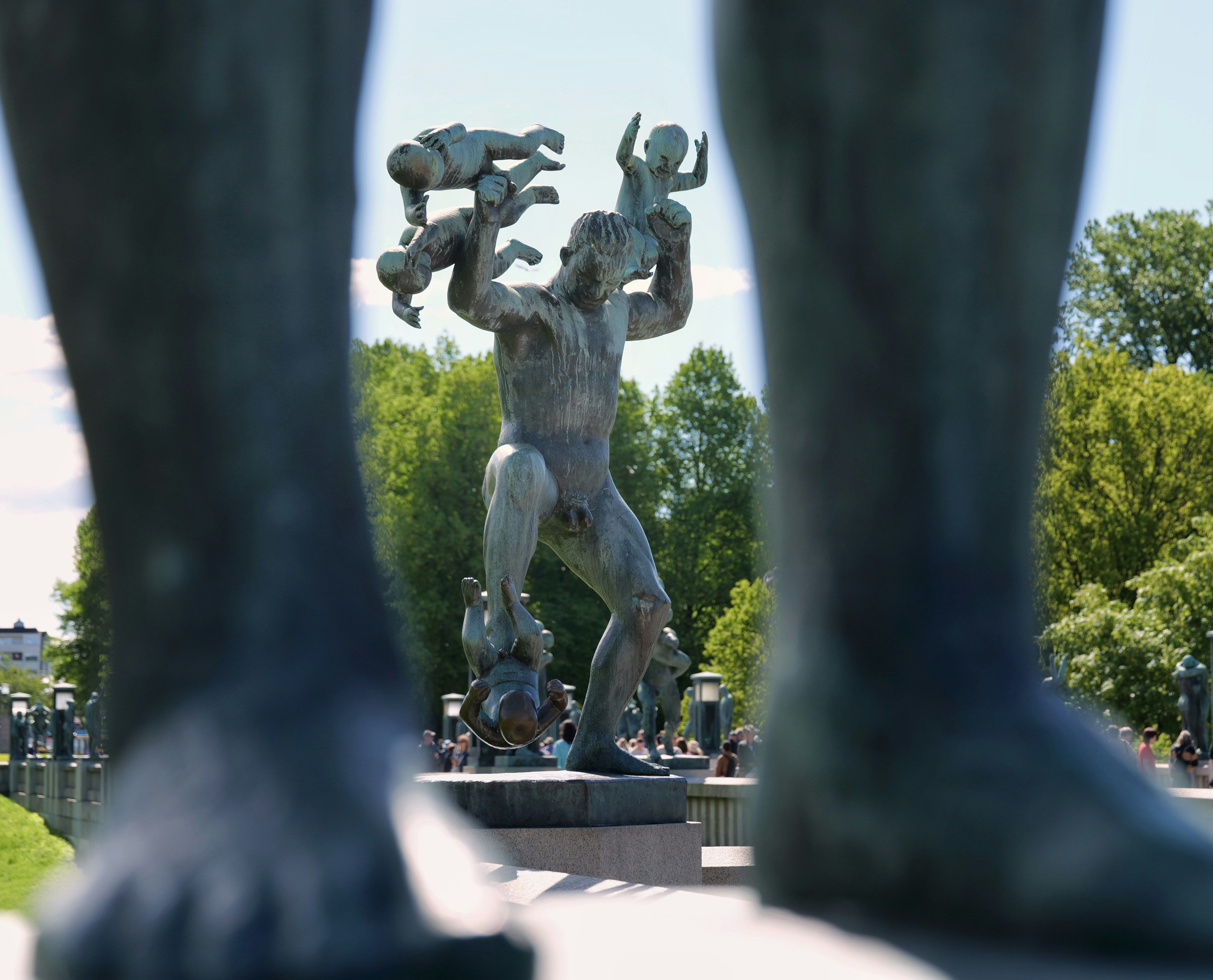 Statue of a man holding babies, framed by large feet
