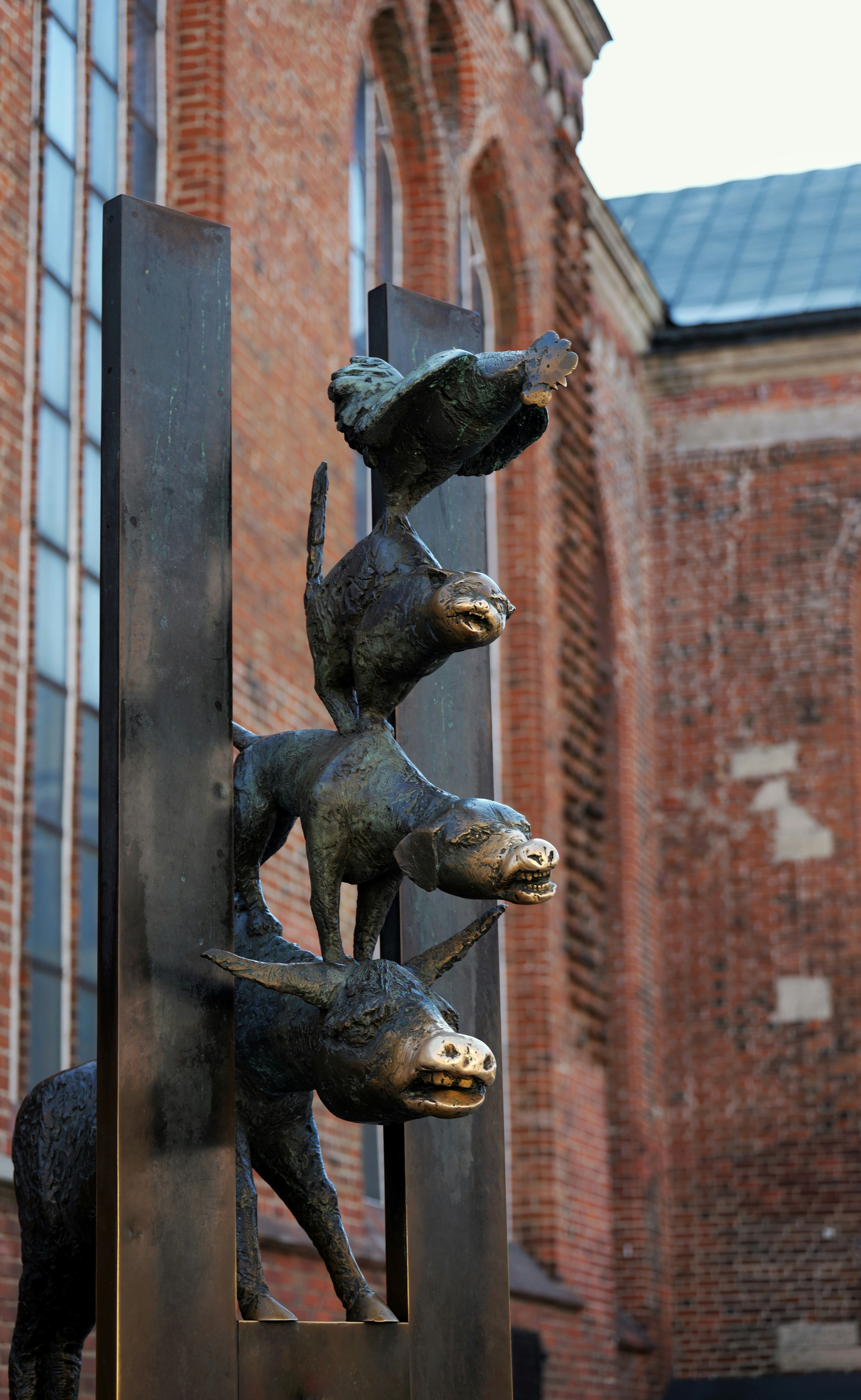 Bronze sculpture of a donkey, dog, cat, and rooster.