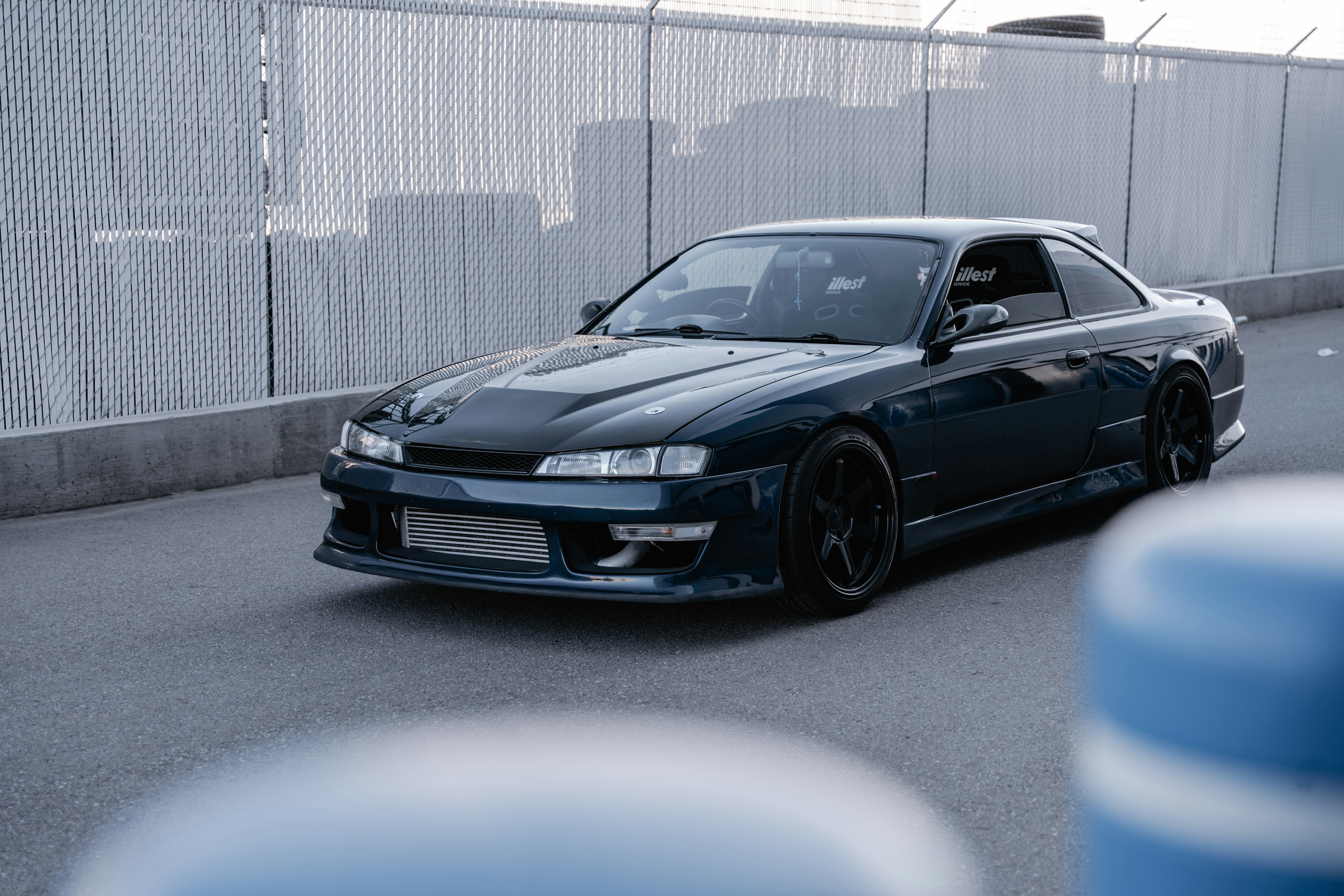 A sleek dark blue sports car on asphalt