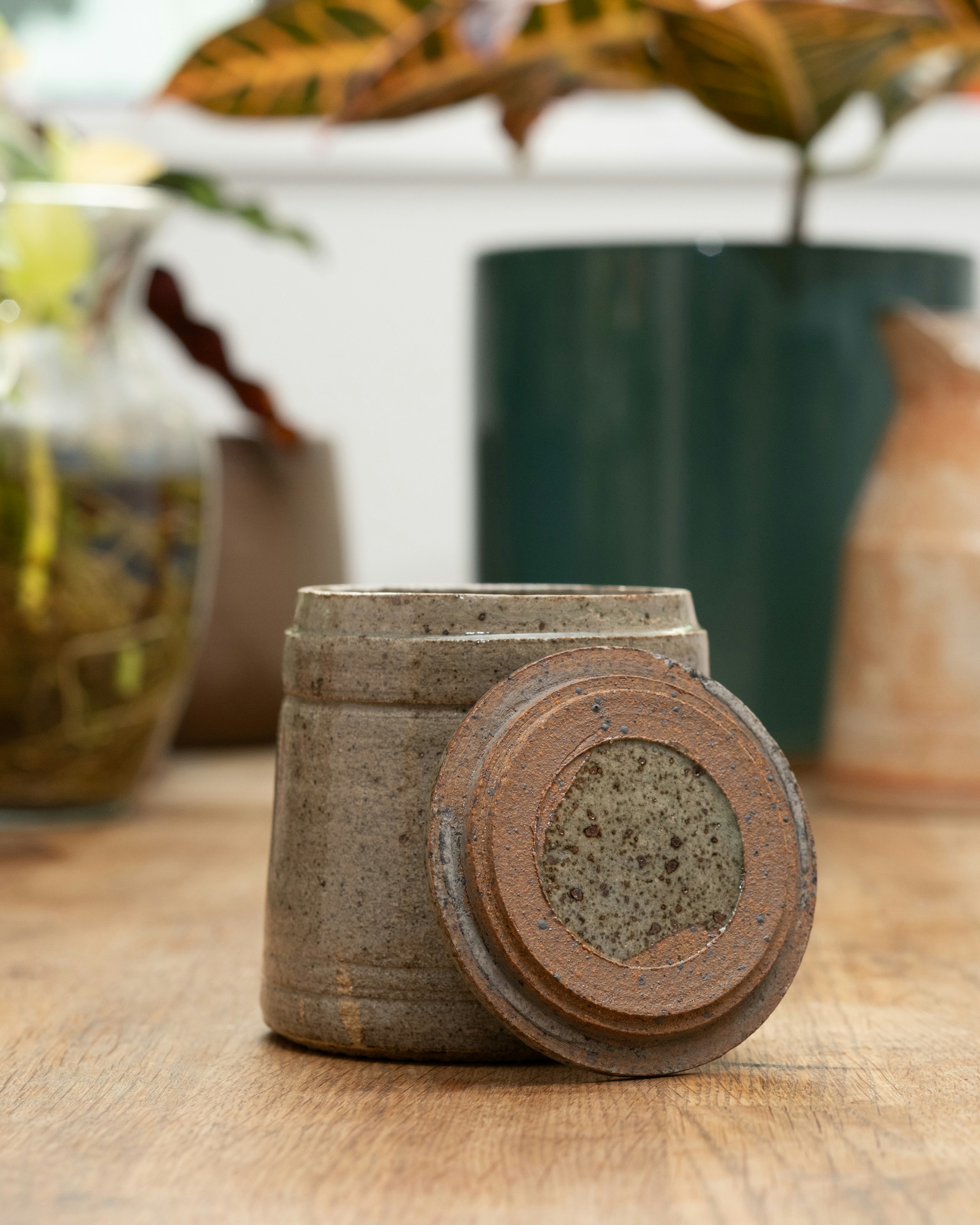 Rustic ceramic kitchenware arranged on a warm wooden surface