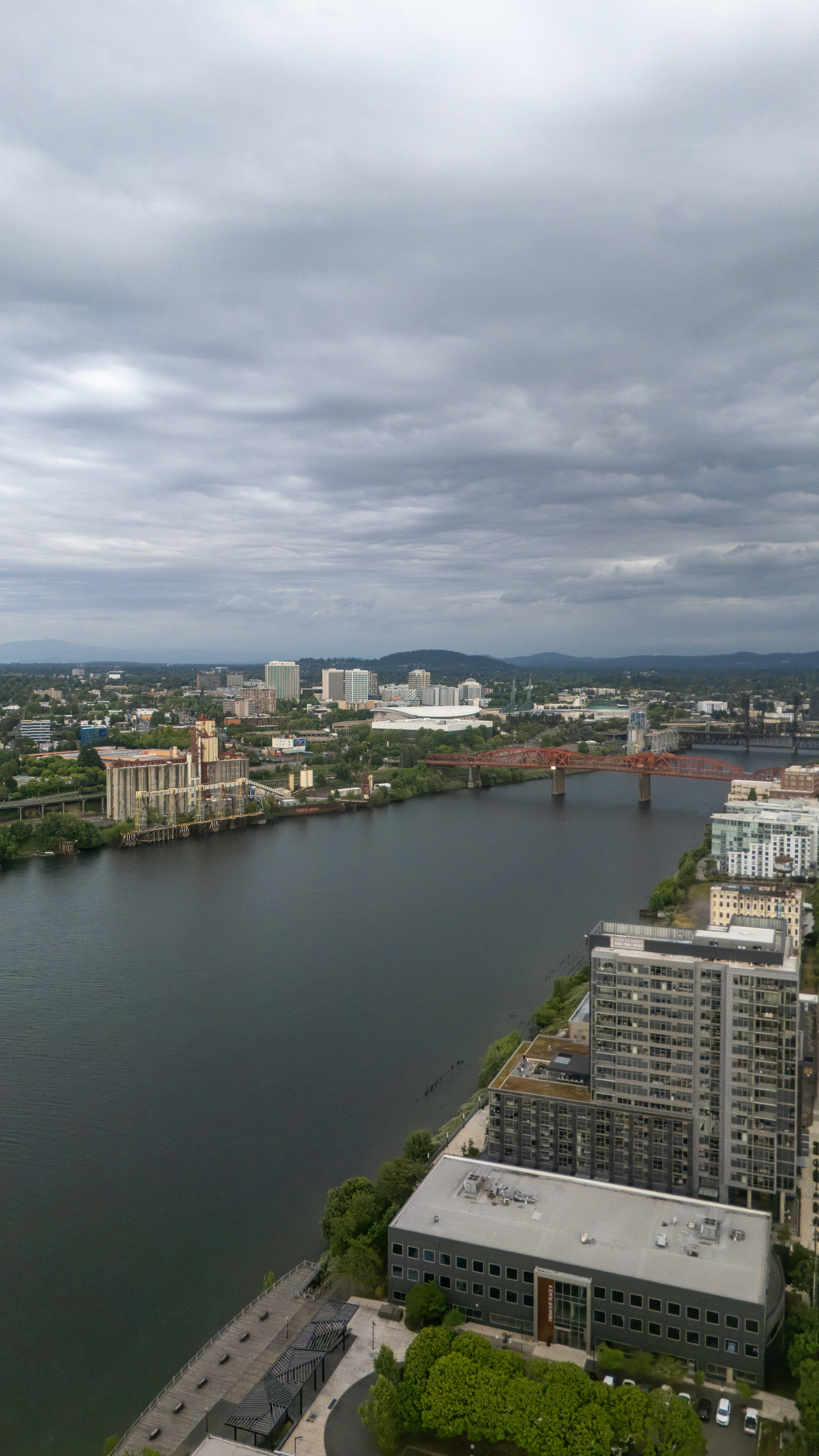 Overcast city skyline with river and bridge