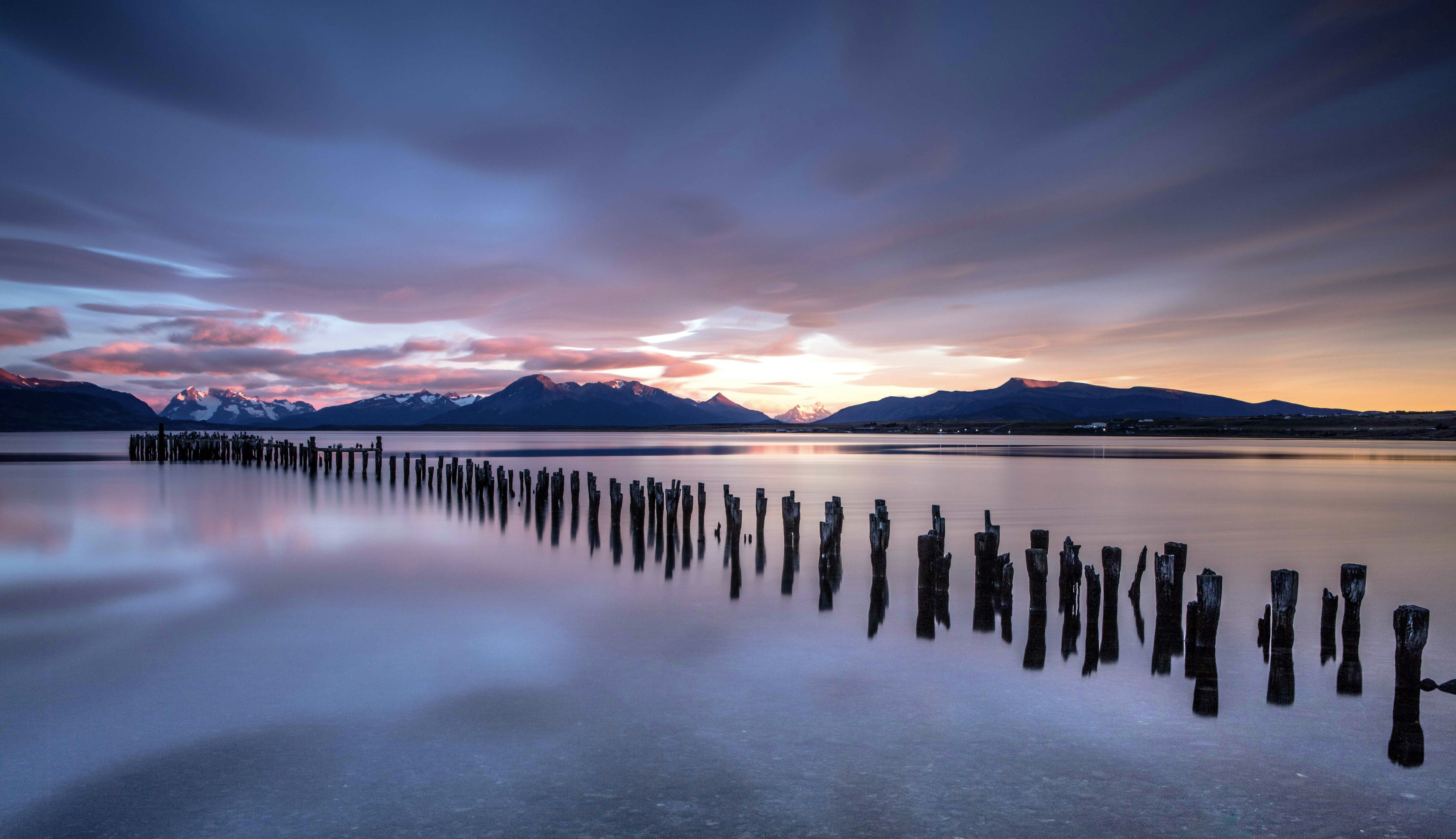 Wooden posts in patagonian lake at sunrise