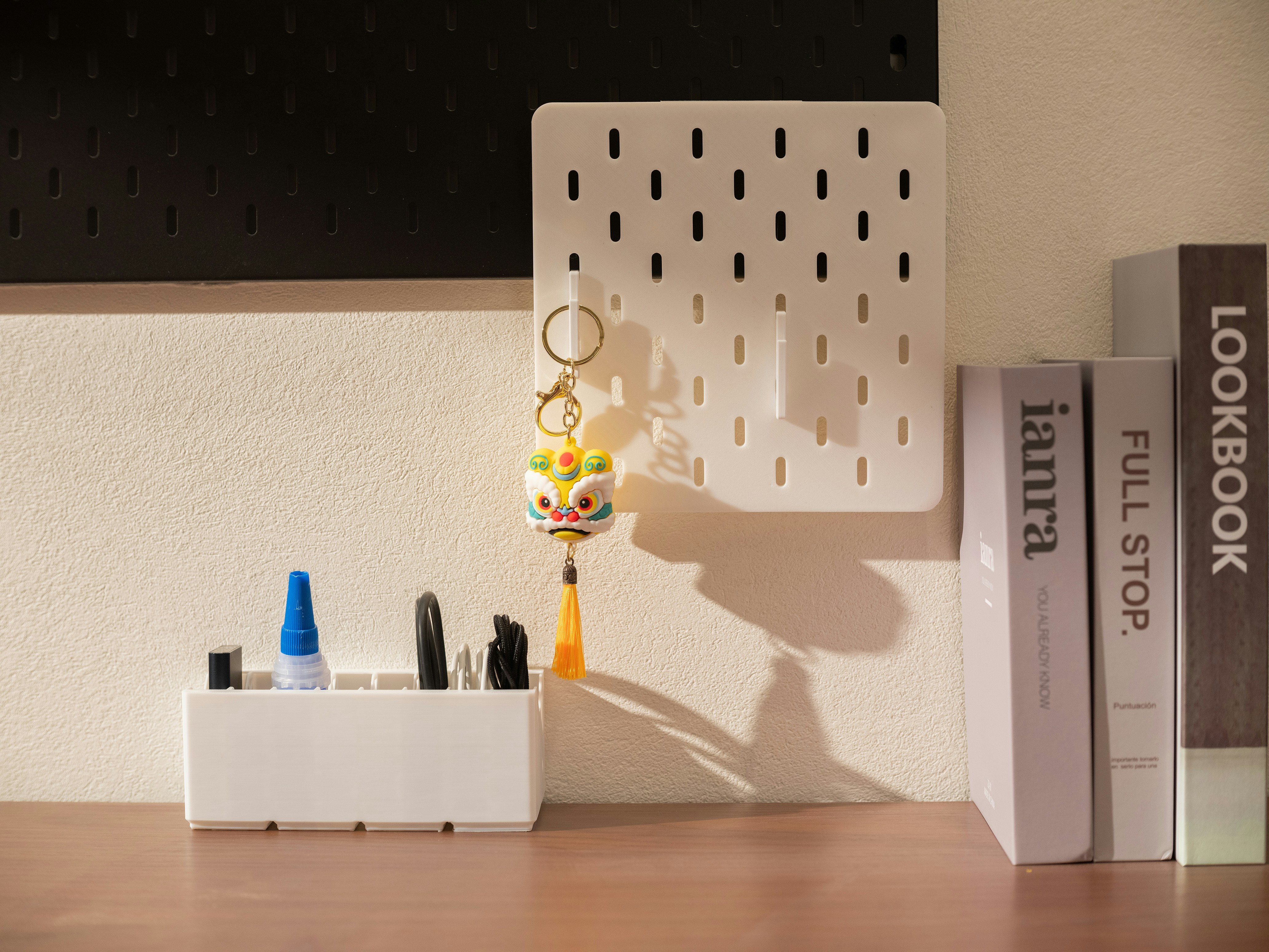 Organisierter Schreibtisch mit weißem Pegboard, Büchern und Schreibwaren.