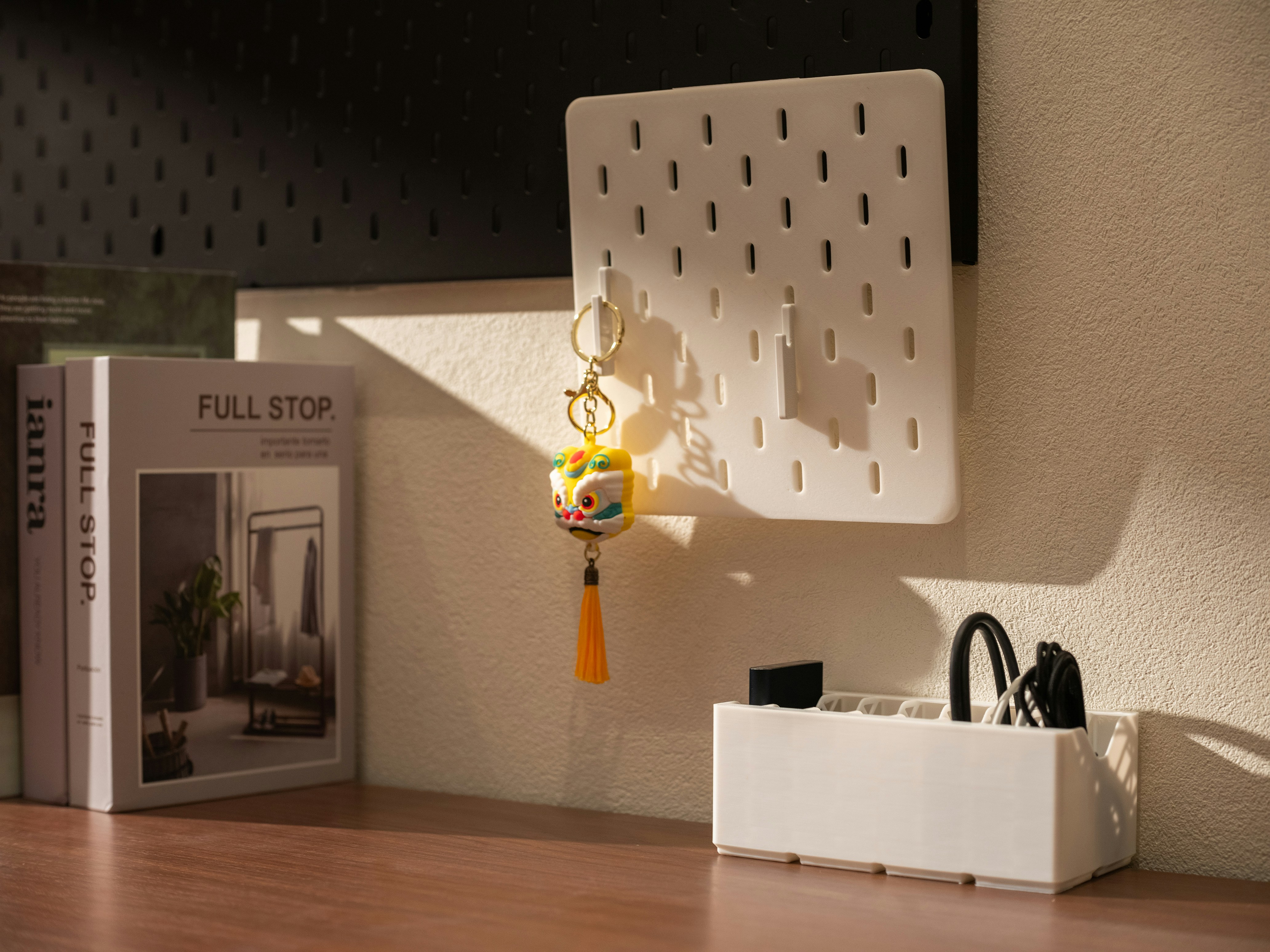 Schreibtisch mit weißem Pegboard, Buch und Organizer mit Schere.