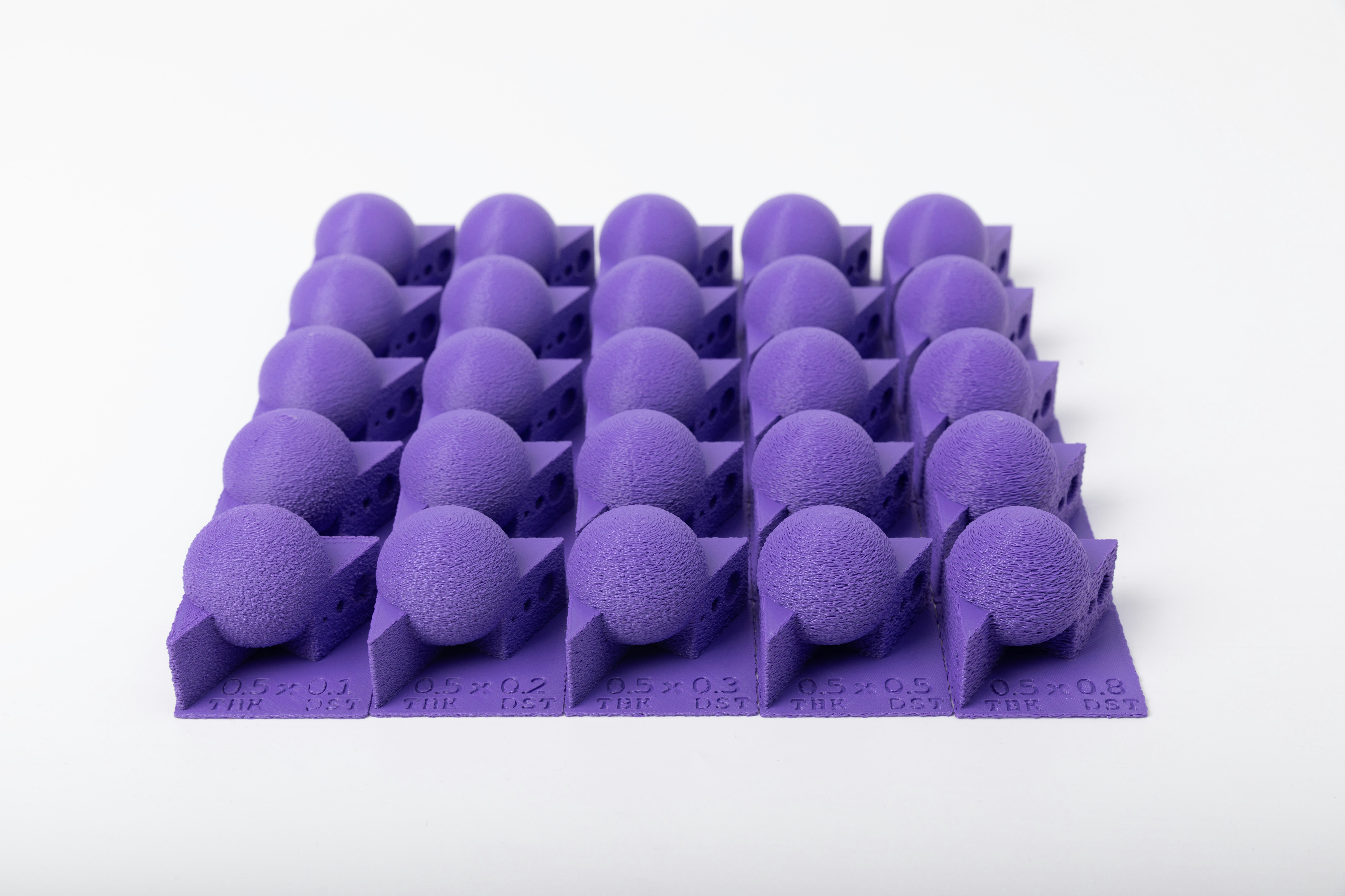 Ein Raster aus violetten Kugeln auf einer lila Basis.