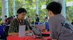 Two men at a table with a laptop.