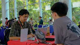 Two men at a table with a laptop.