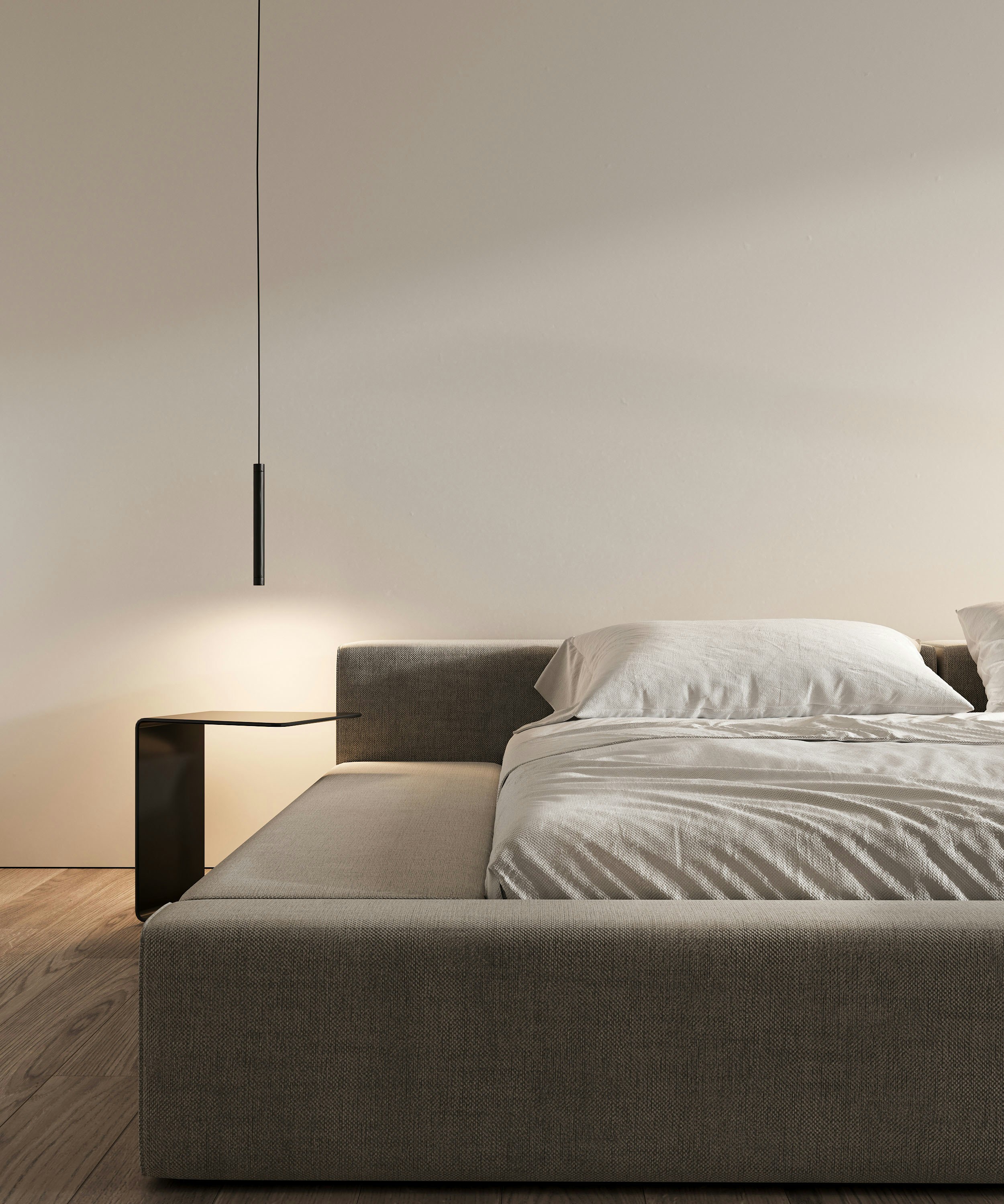 Contemporary bedroom with a gray bed and illuminated bedside table.