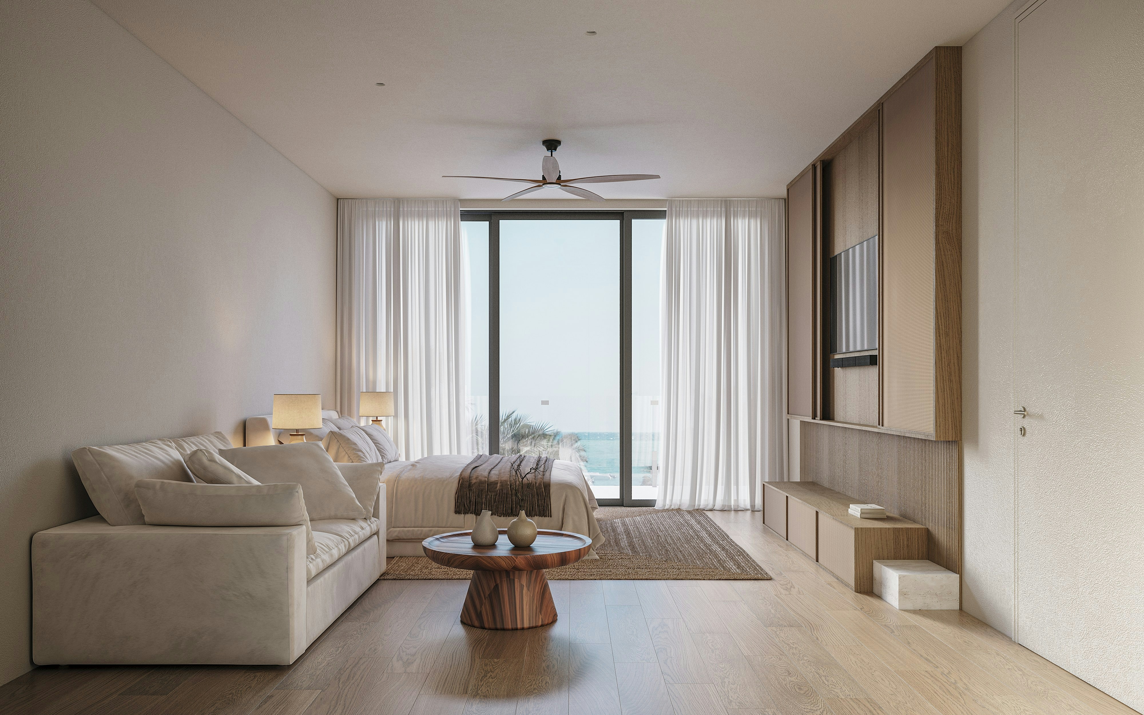 Modern bedroom with ocean view, sofa, and wooden floor.