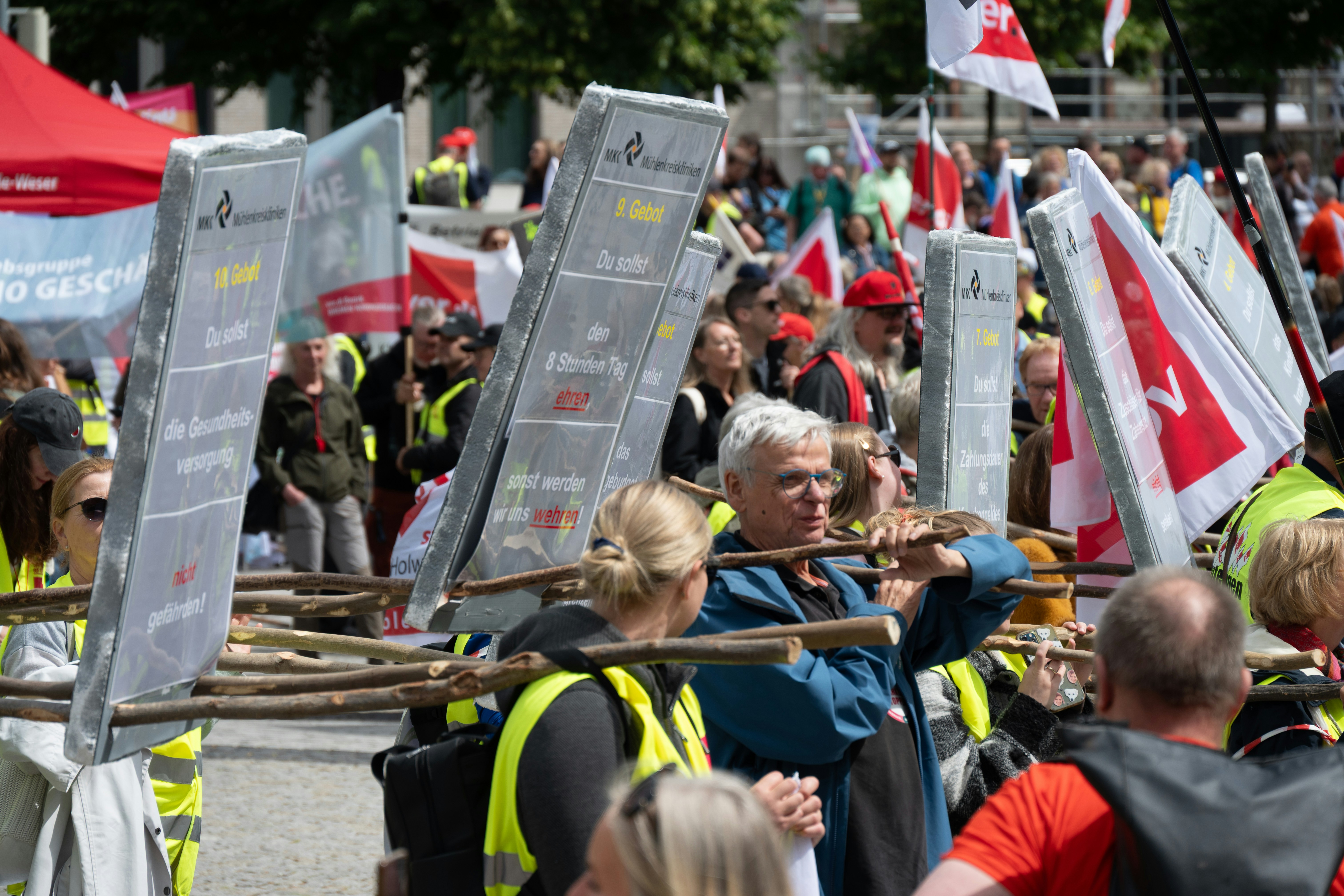 Menschen protestierten draußen mit Schildern und Fahnen.