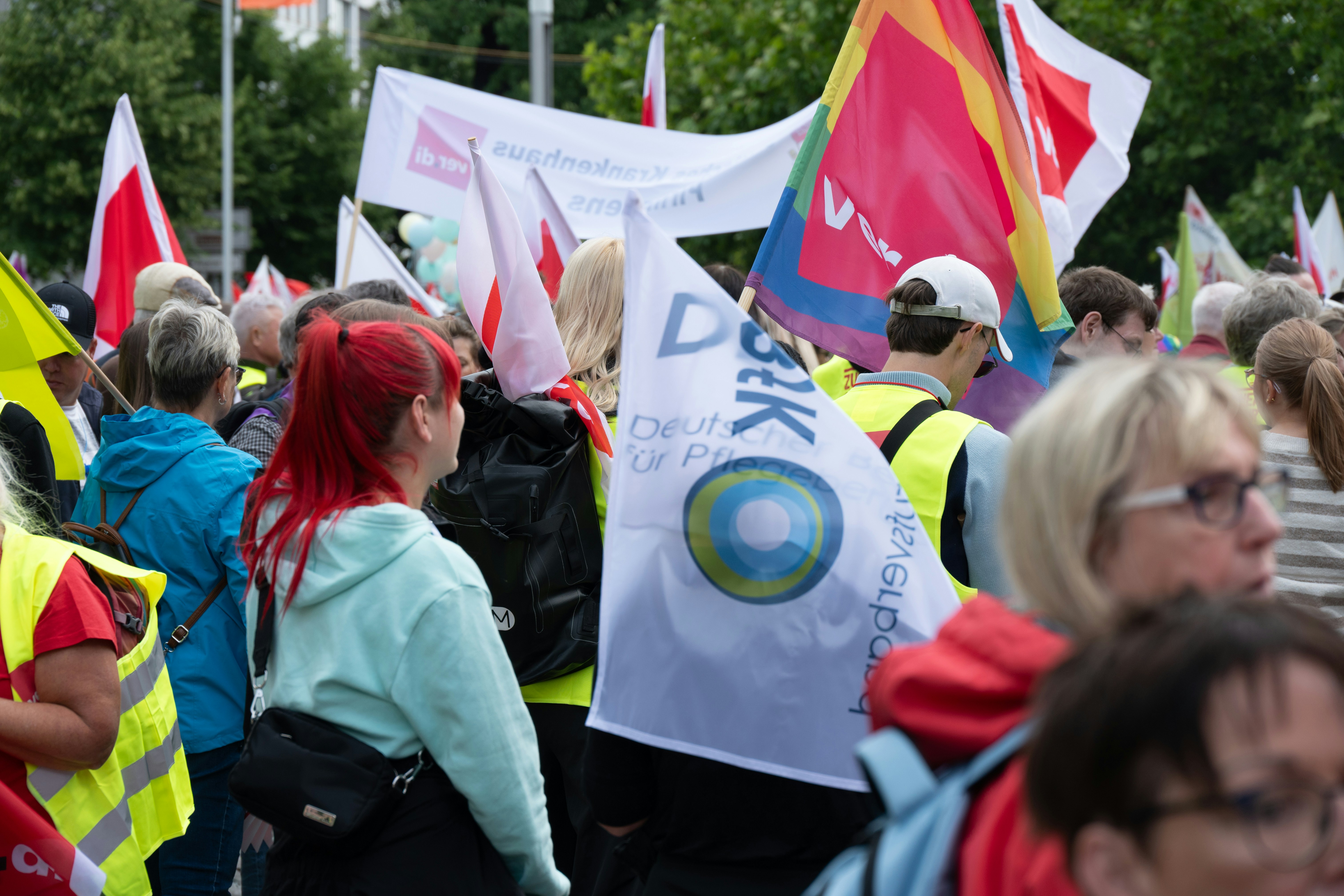 Demonstranten, die Flaggen und Banner in einer großen Menschenmenge halten.