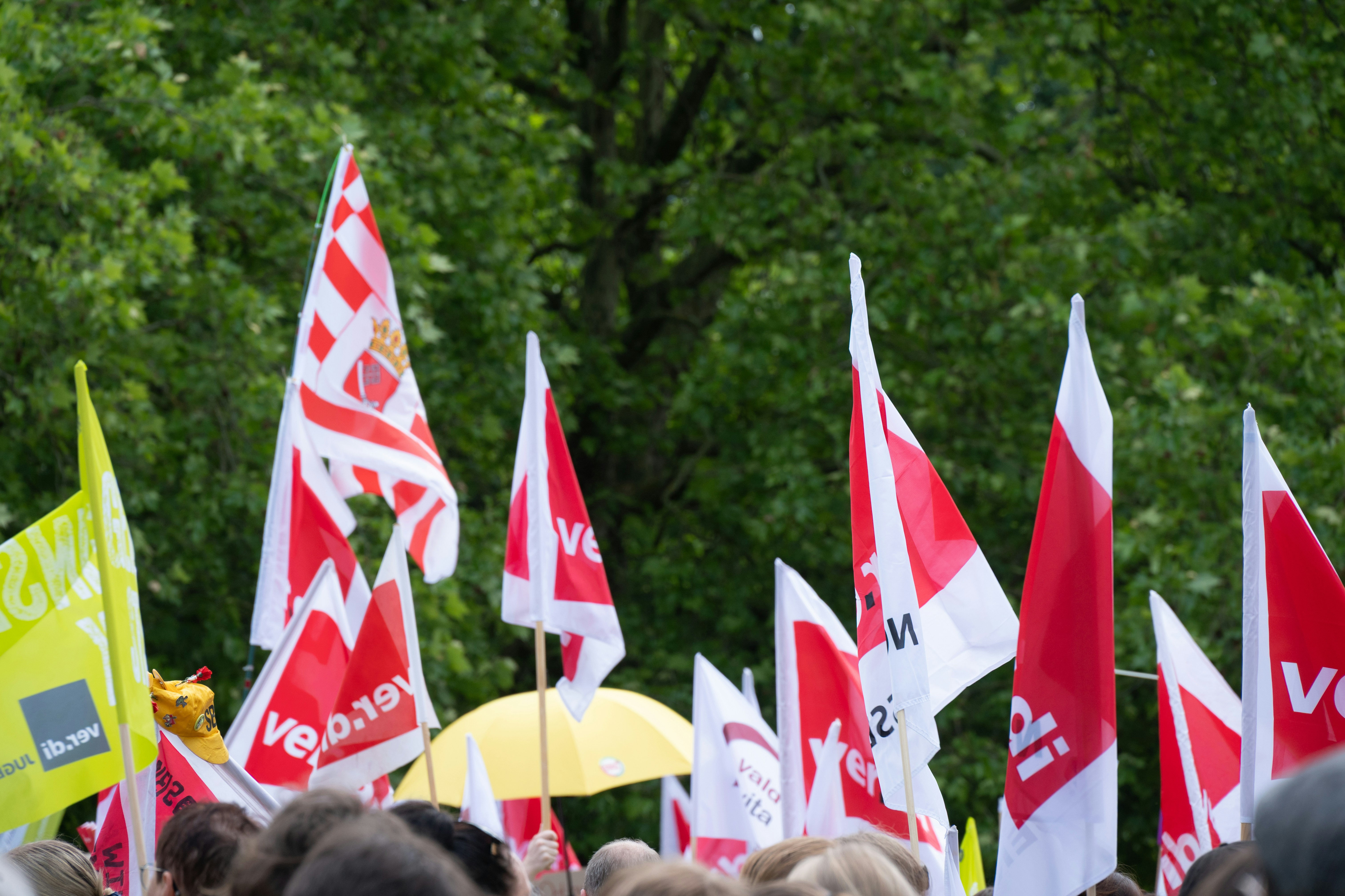 Eine Menschenmenge mit roten und weißen Fahnen.