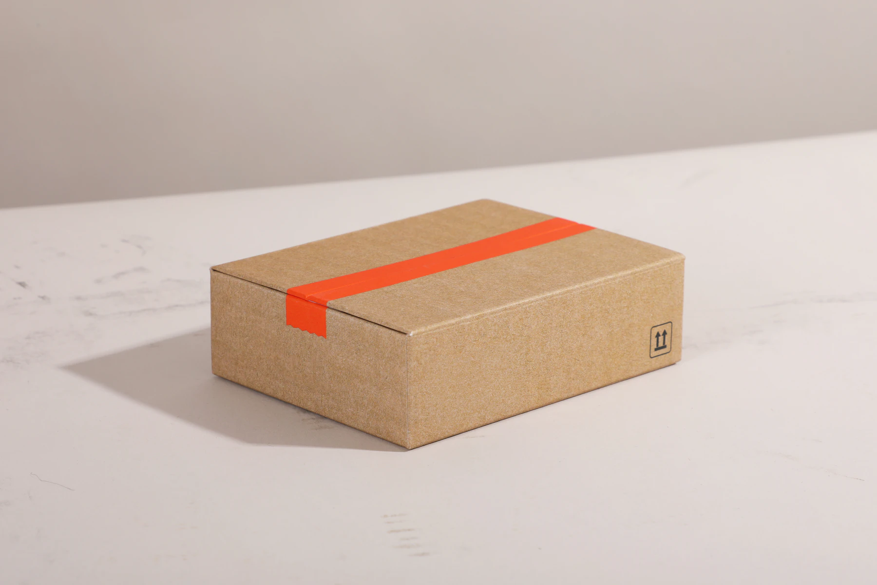 Brown cardboard box with bright orange tape