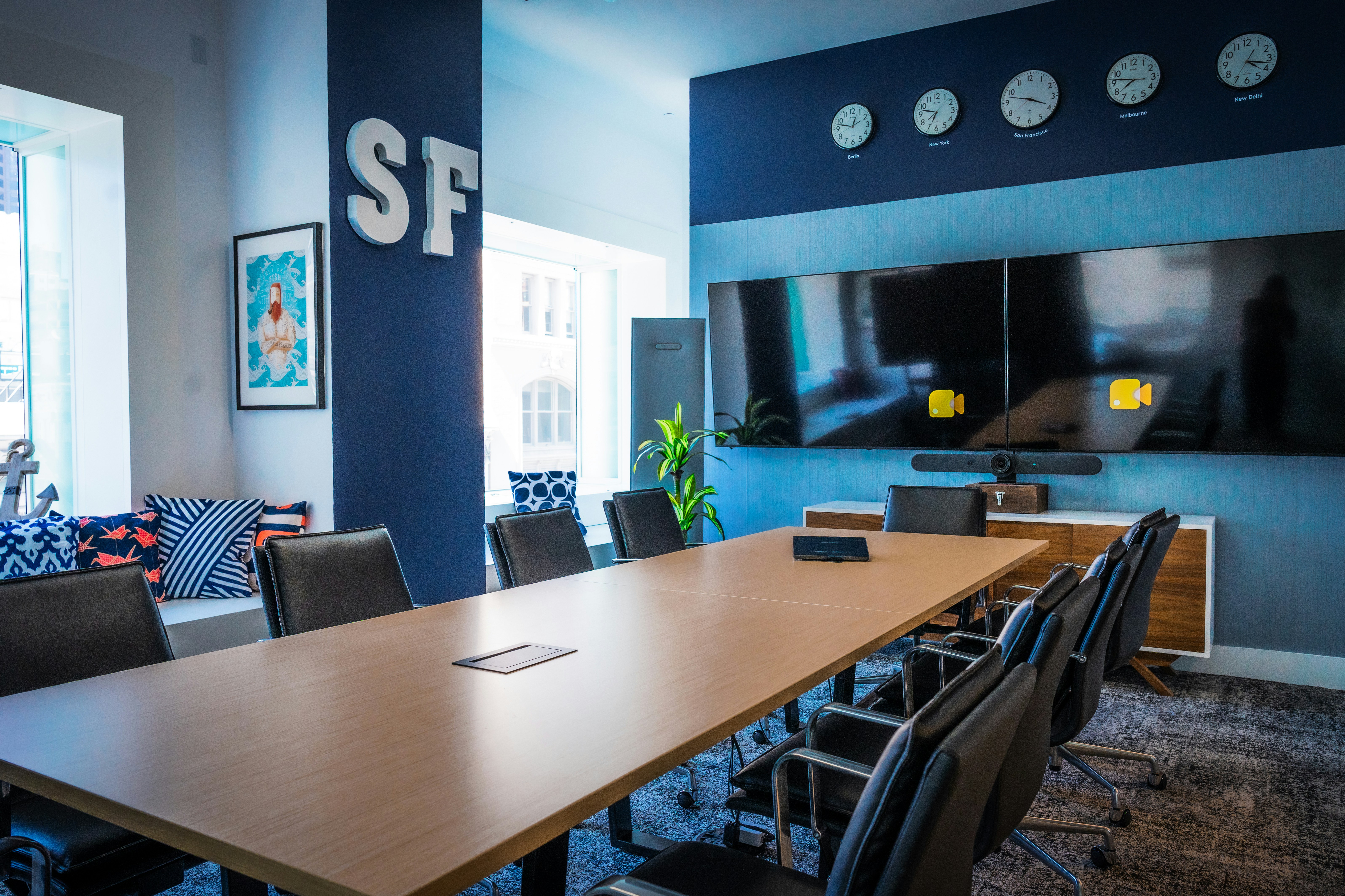 Modern conference room with a long table and multiple screens