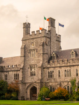 Grand stone building with flags and autumn foliage