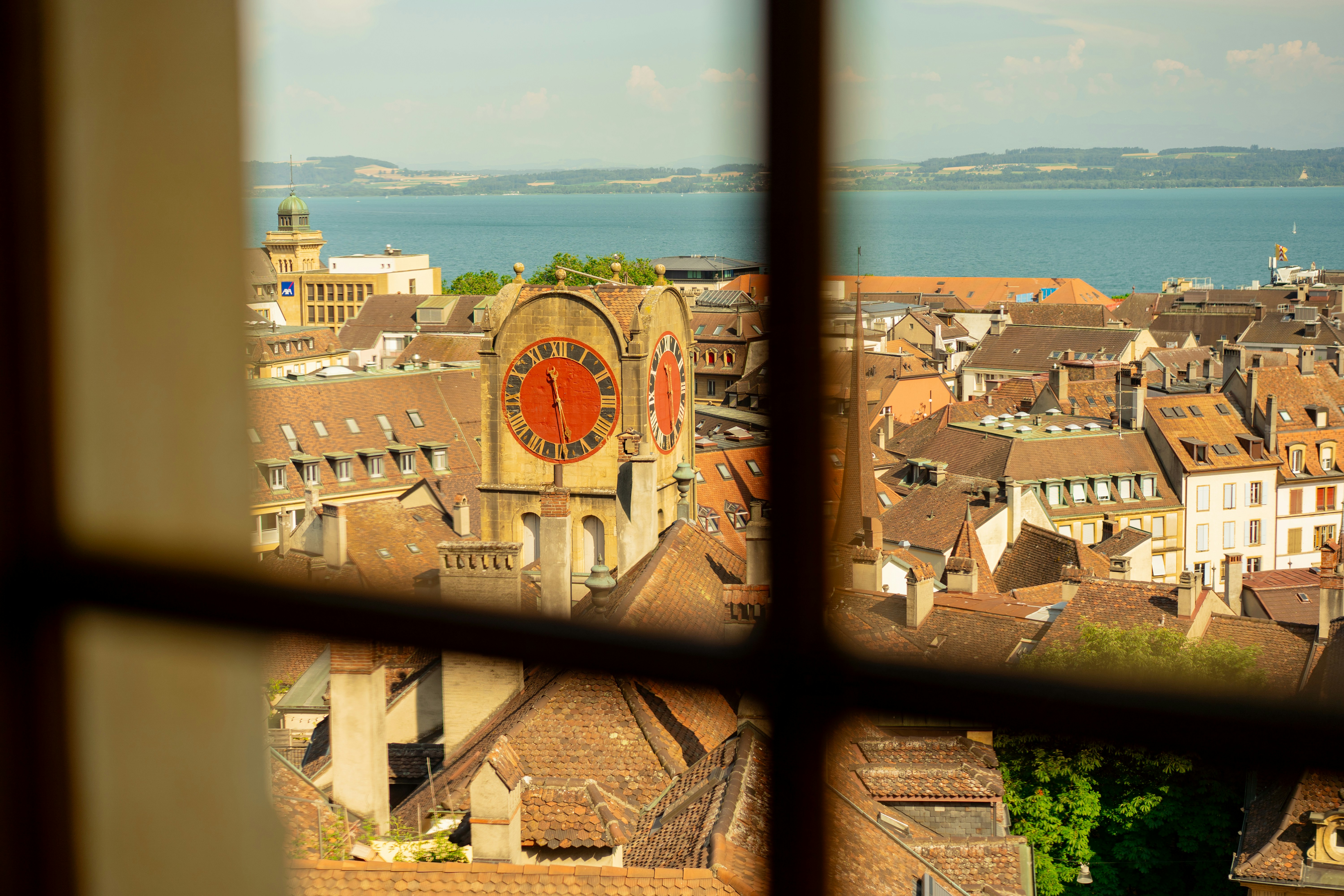 Scenic view of an old city, clock tower, and lake.