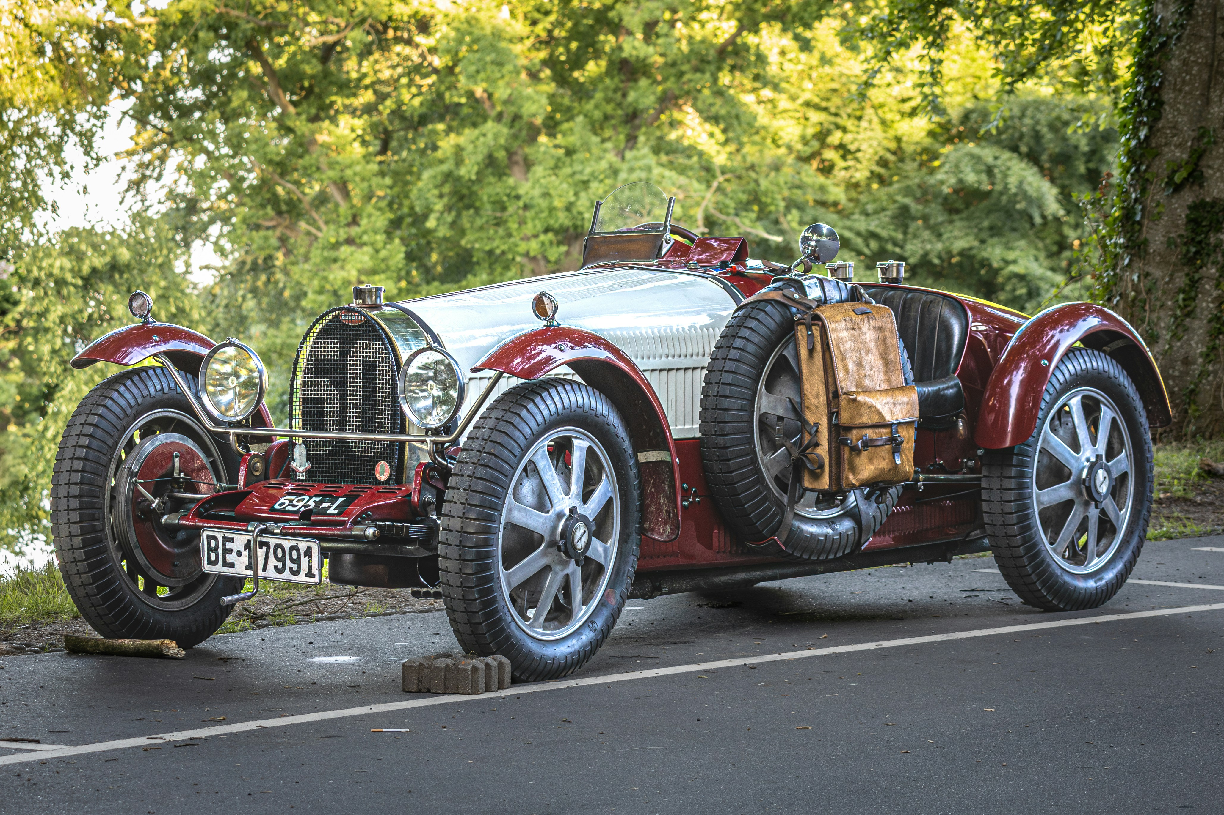 A classic red and white bugatti car with number 50.