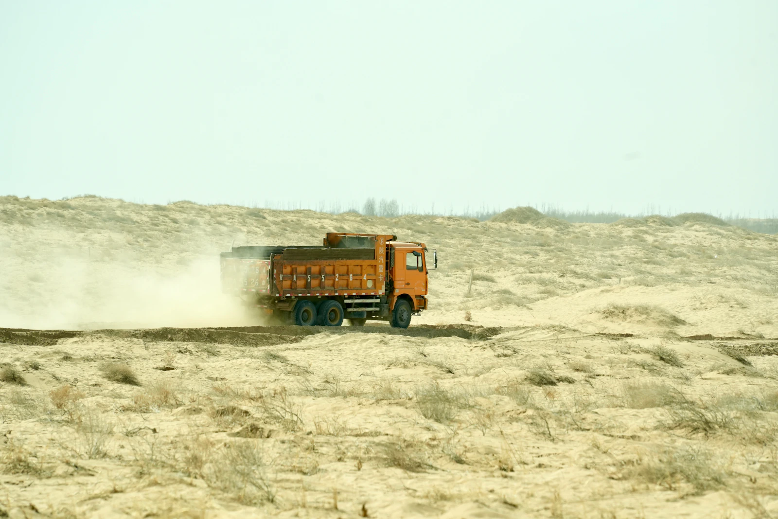 Heavy haul truck travelling through a dusty industrial site