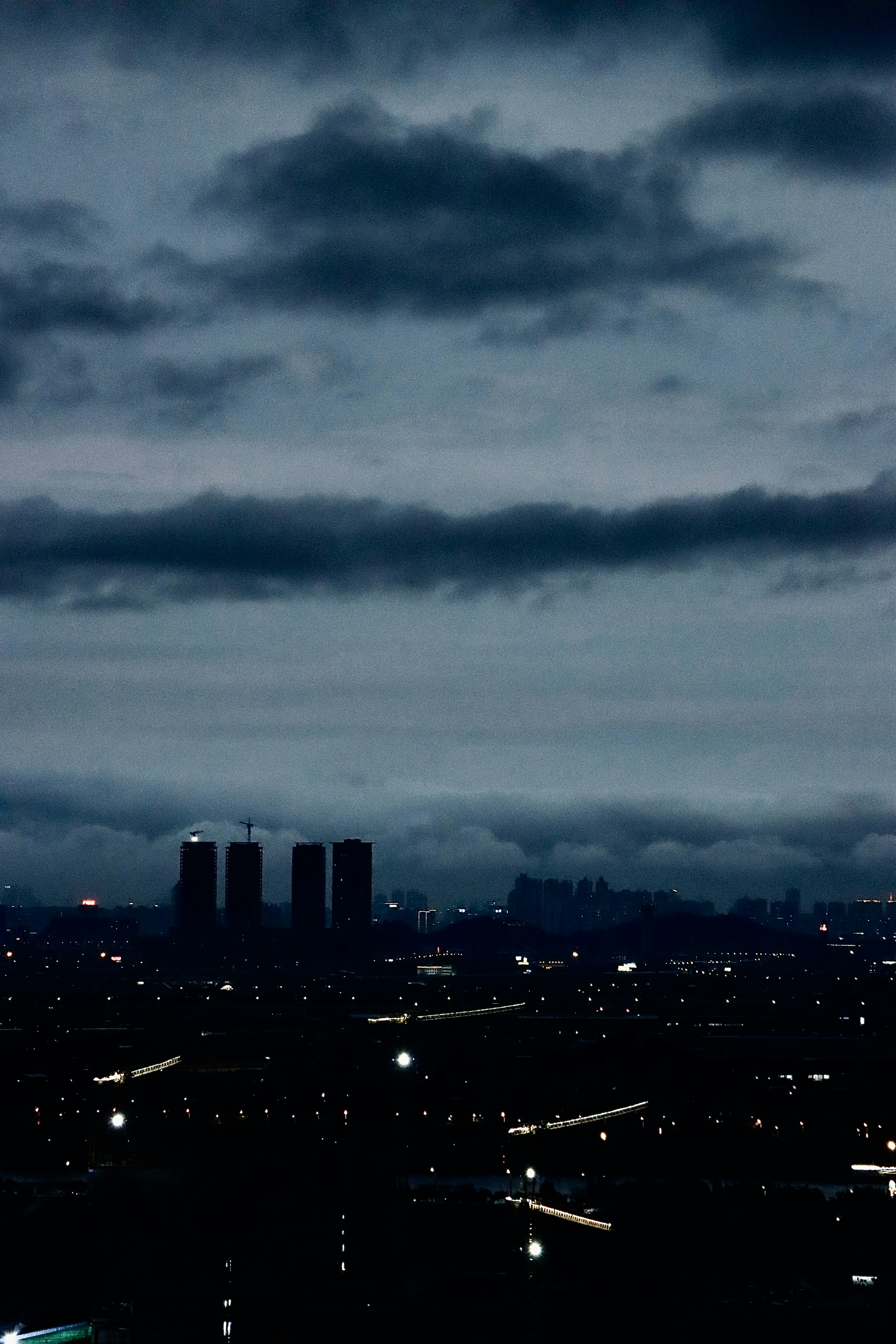 Gloomy, overcast sky above a city with distant lights