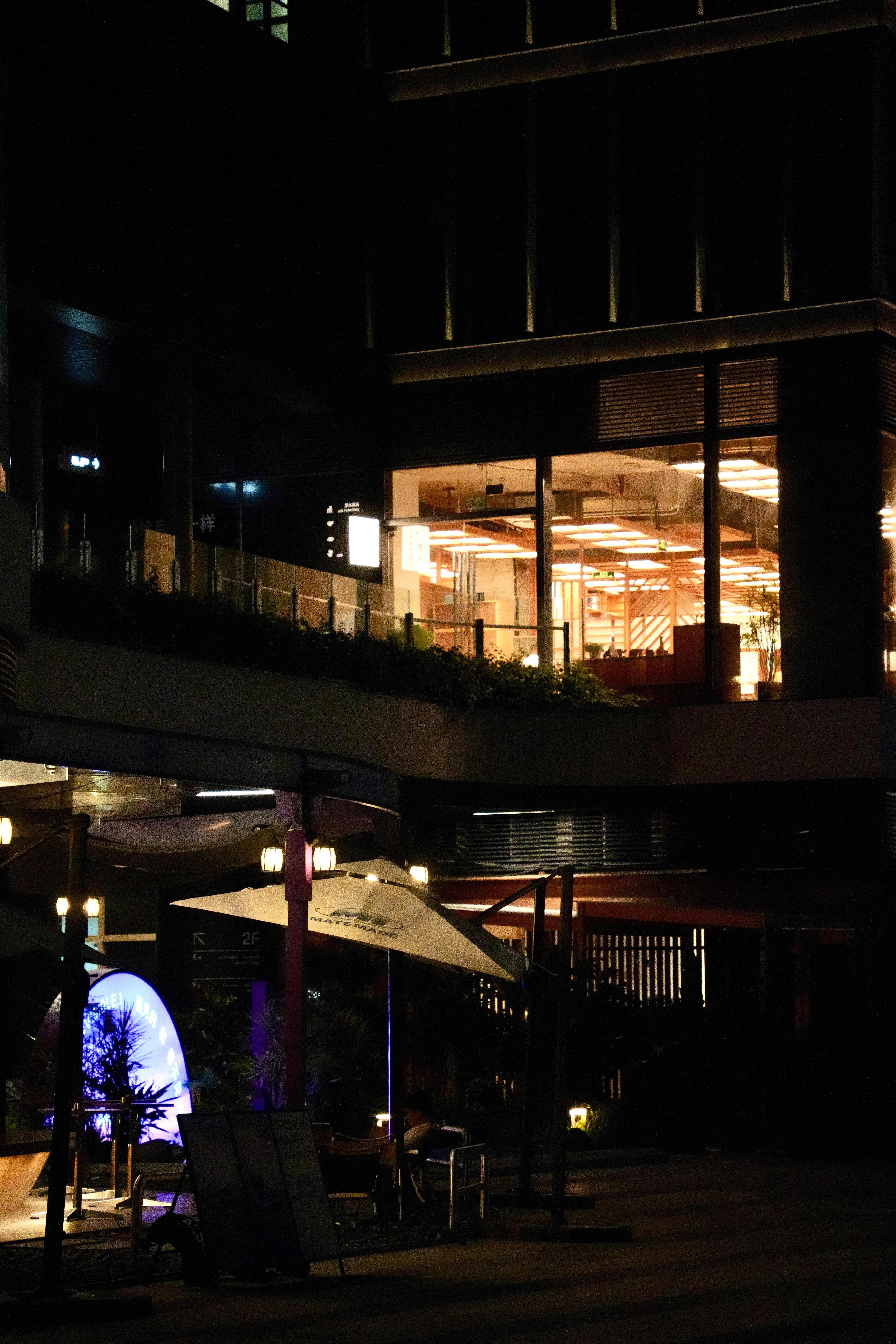Um prédio moderno e uma área de estar ao ar livre iluminada à noite