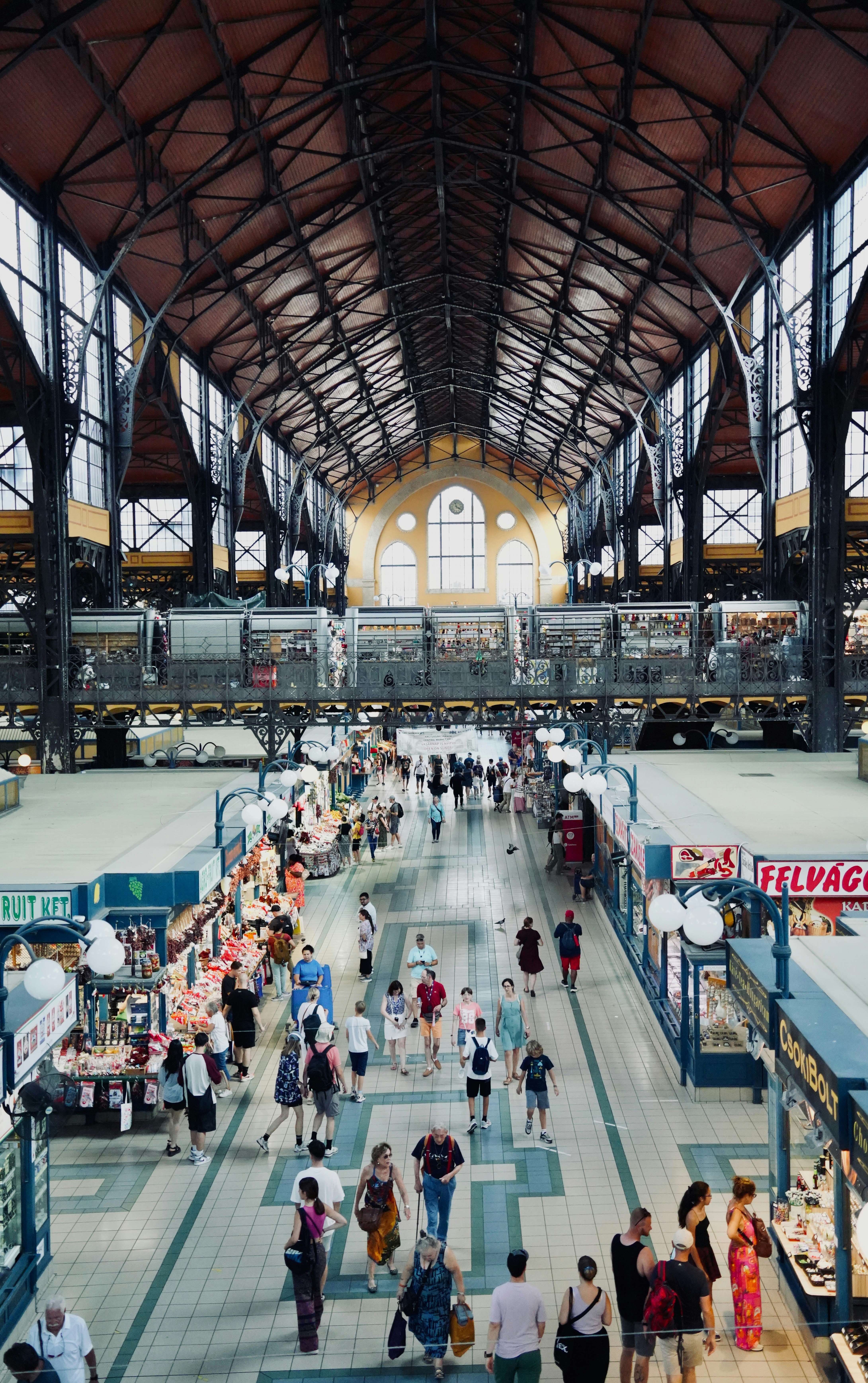 People walking through a grand, busy indoor market hall