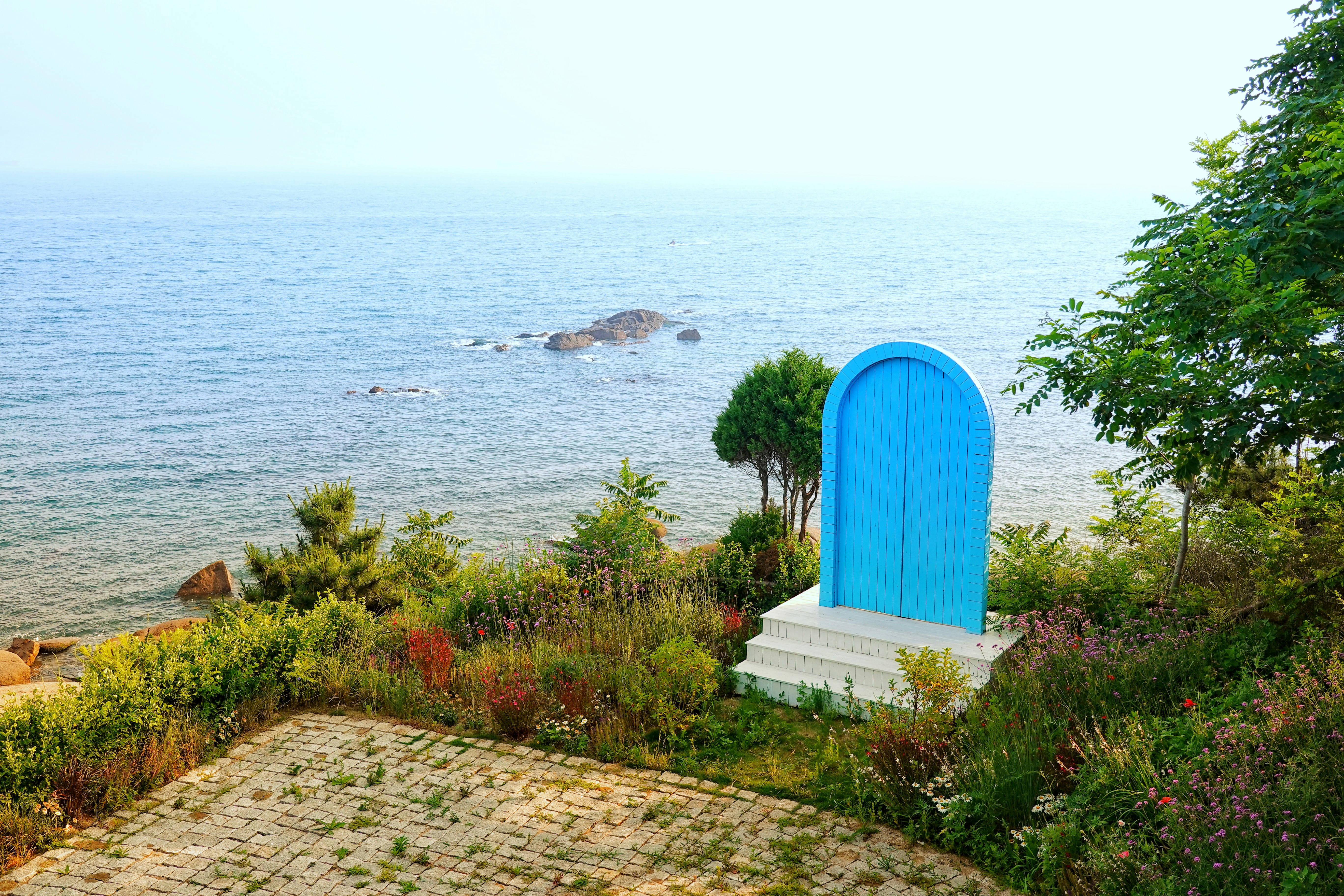 Blue door on a hill overlooking the ocean