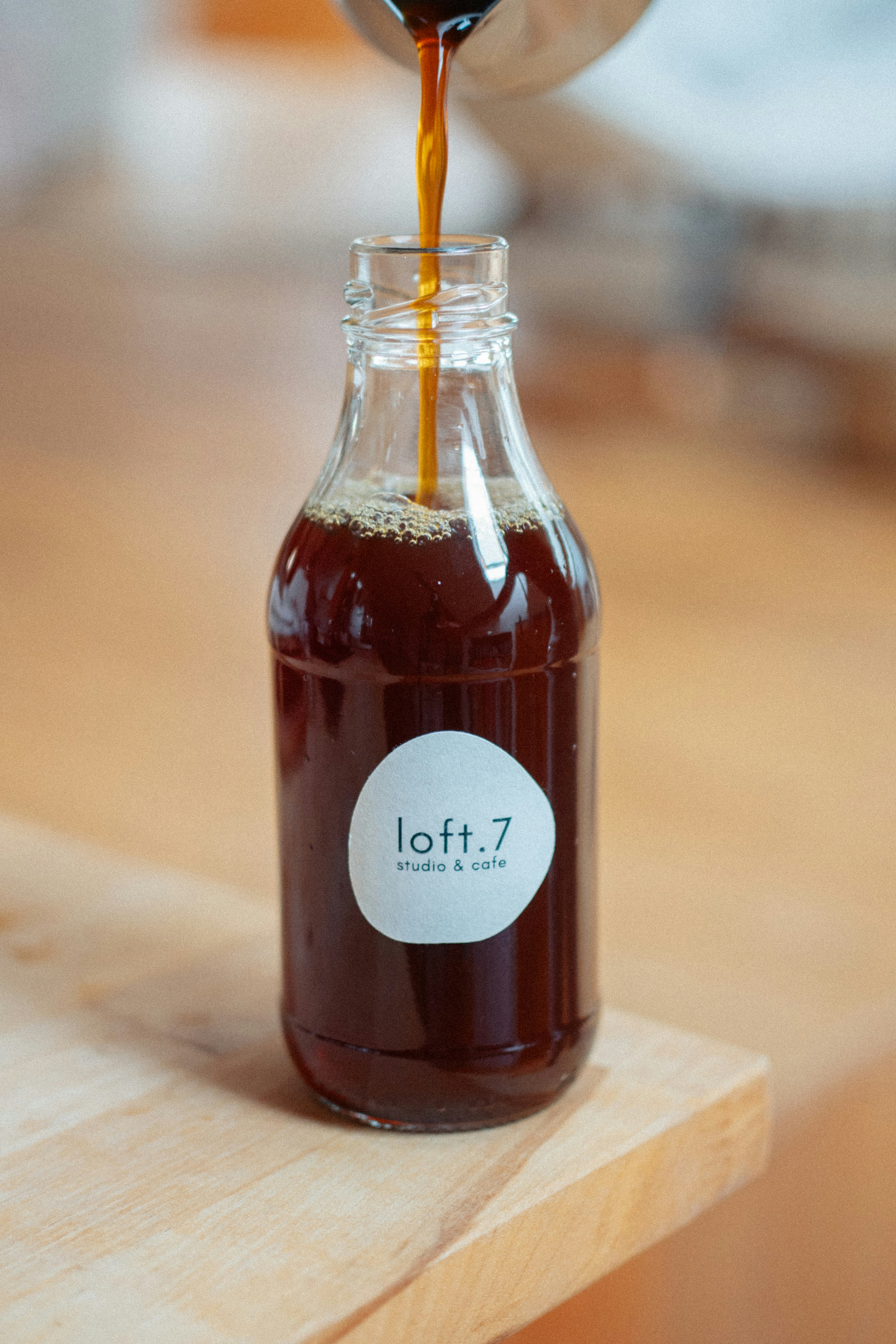 Kopi dituangkan ke dalam botol bermerek "loft.7".