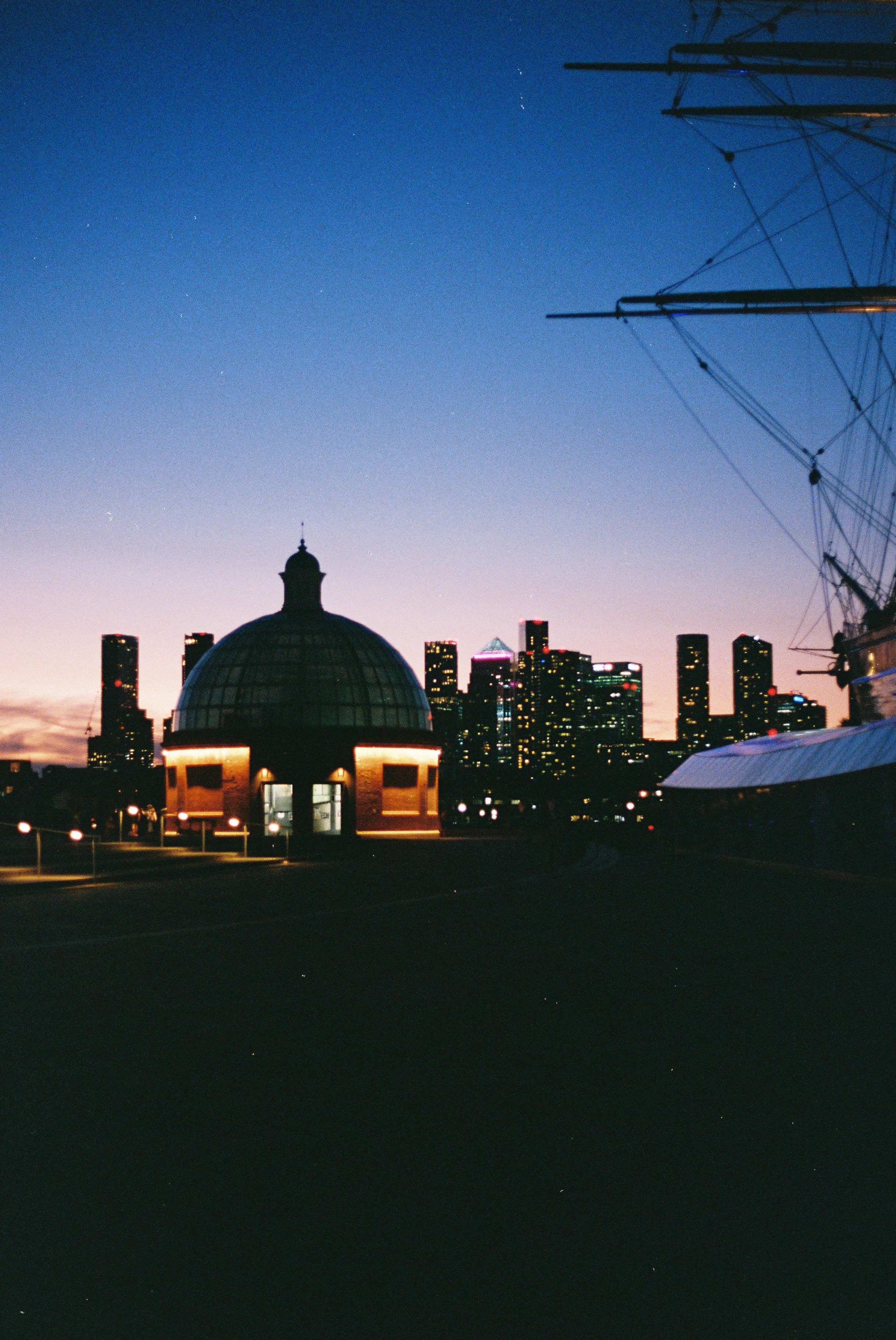 City skyline, domed building, and ship mast at dusk