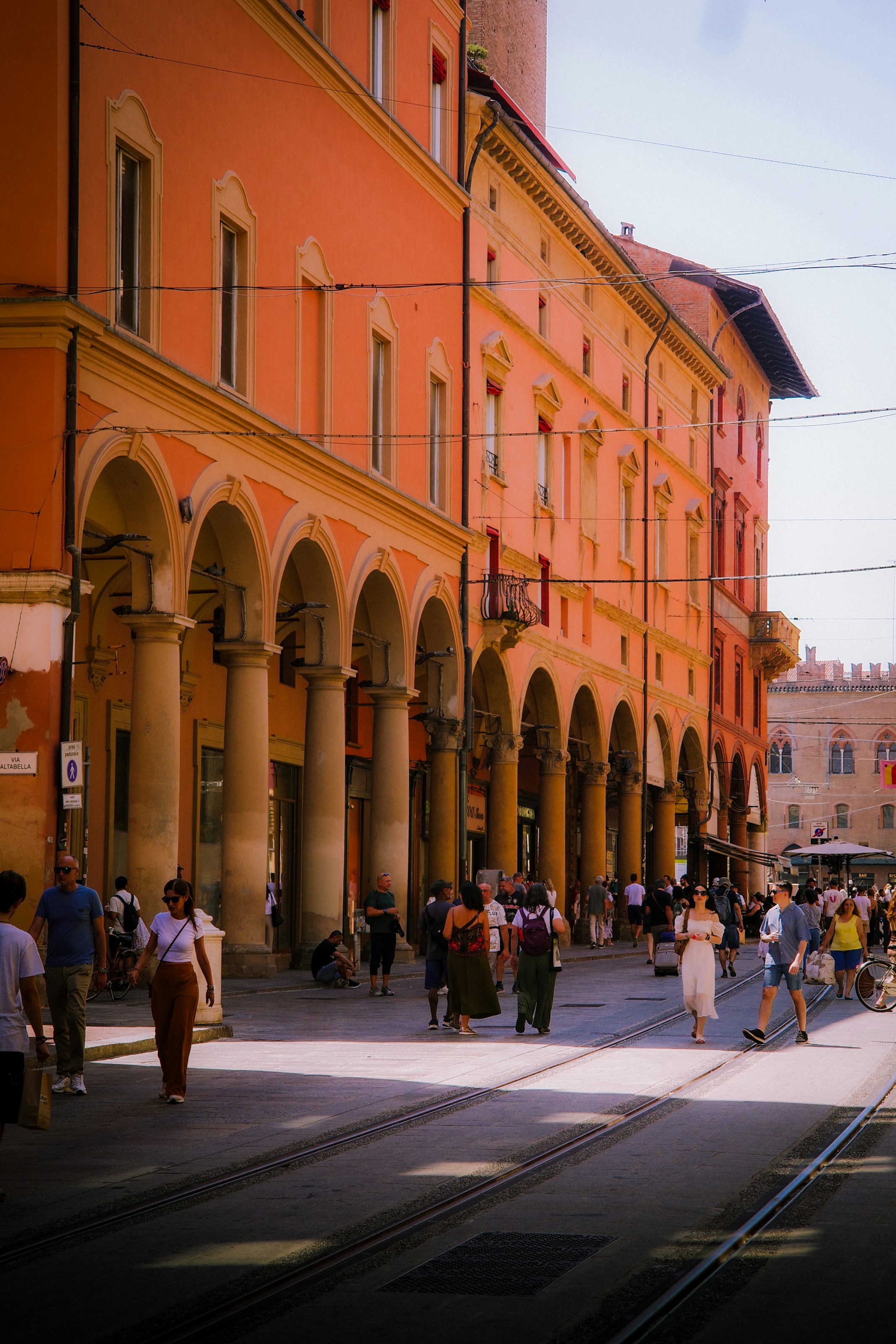 Historic orange buildings with archways line a sunny street