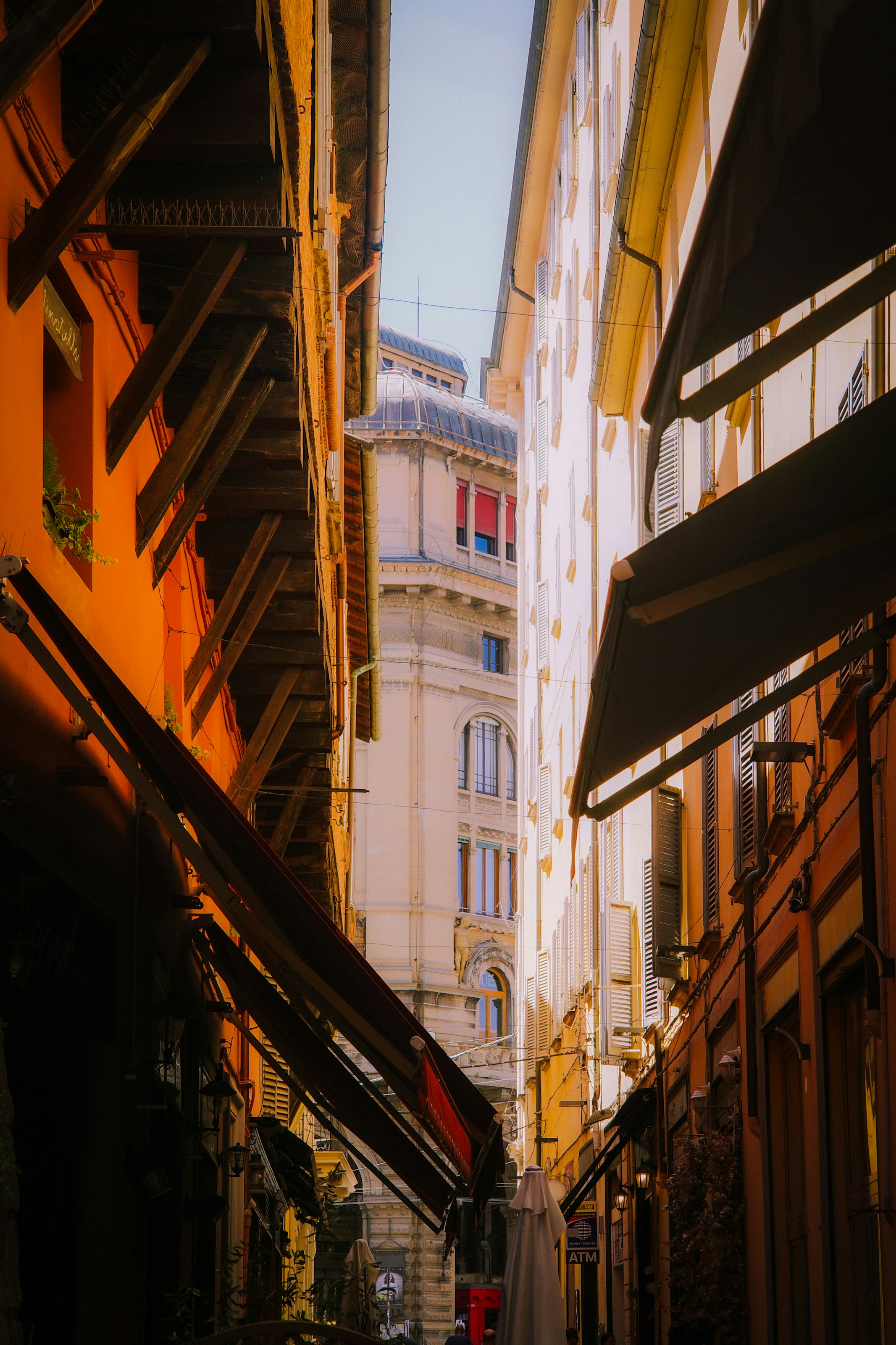Sunlit narrow street winding between historic buildings
