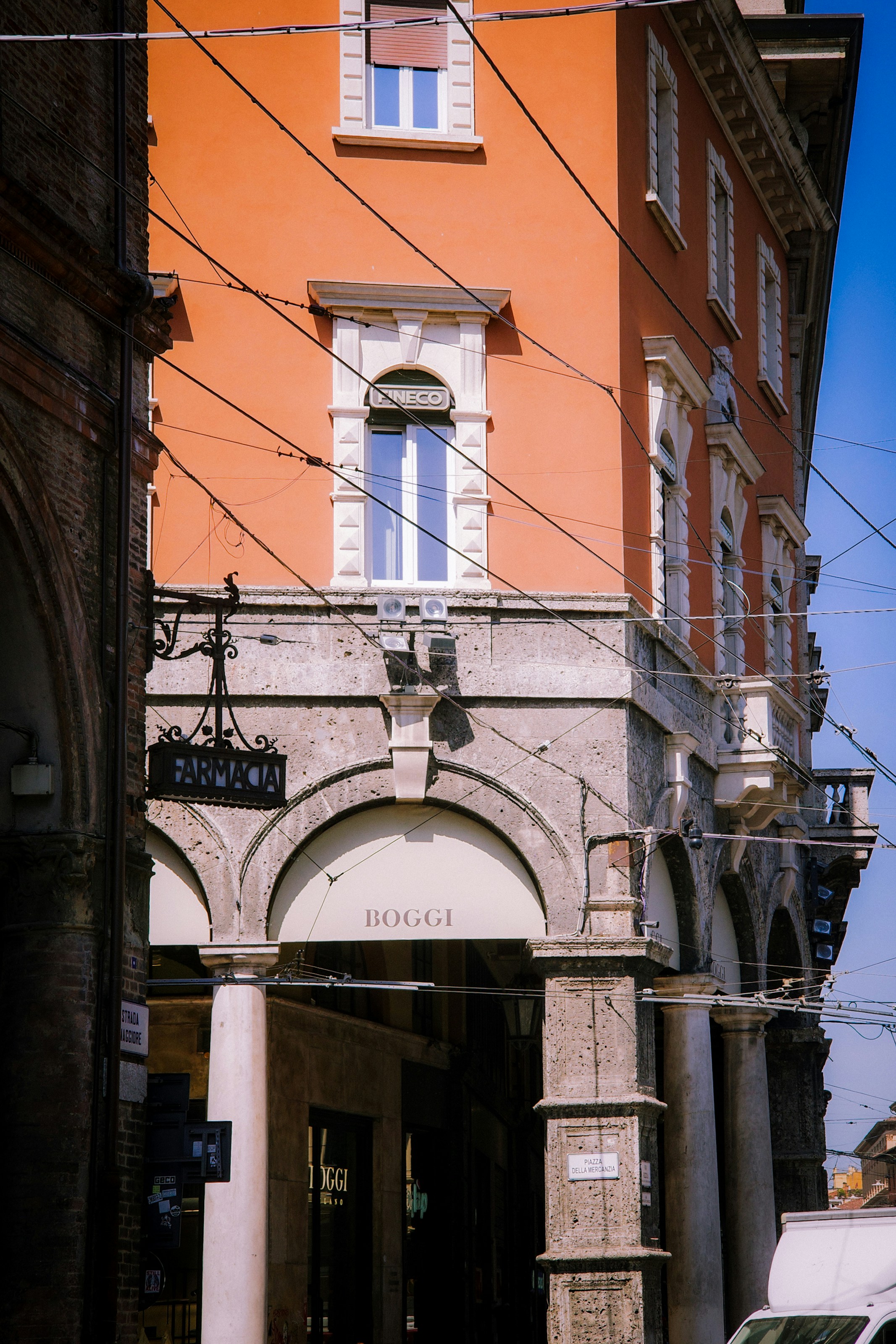 Vibrant orange building with arched entrance and overhead wires