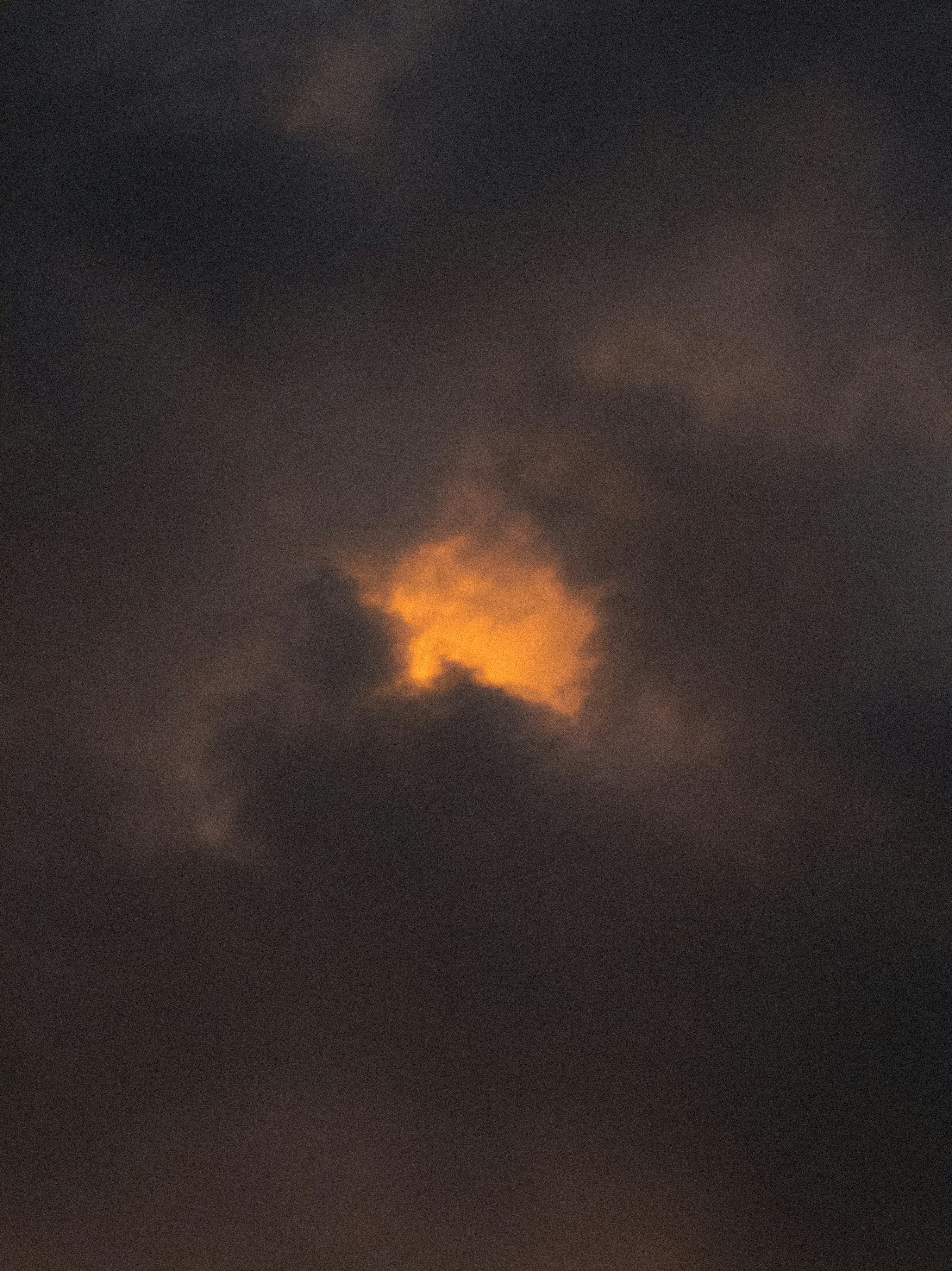 Dark clouds with an orange glow breaking through the center