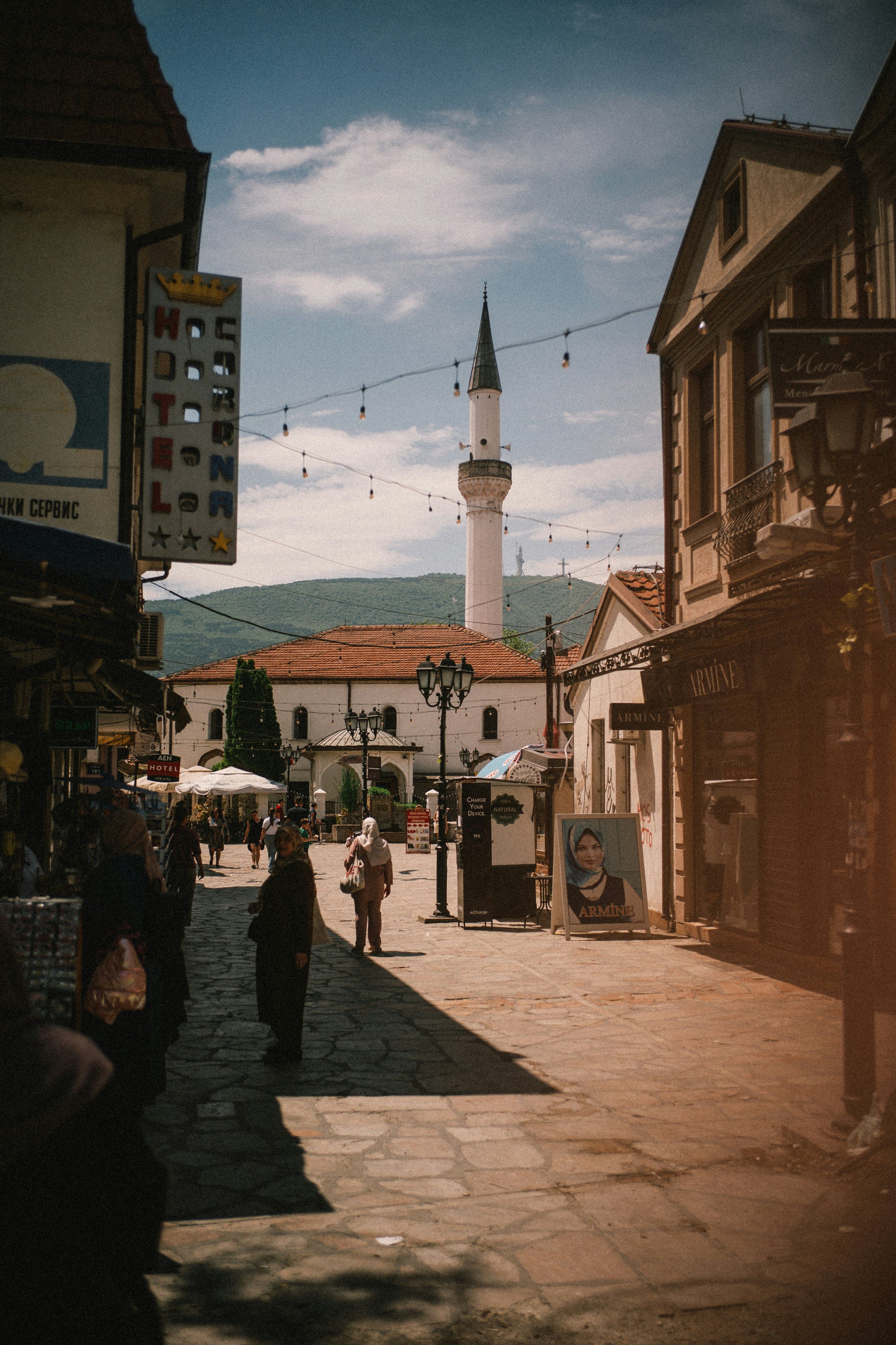 People walk on a historic street towards a mosque